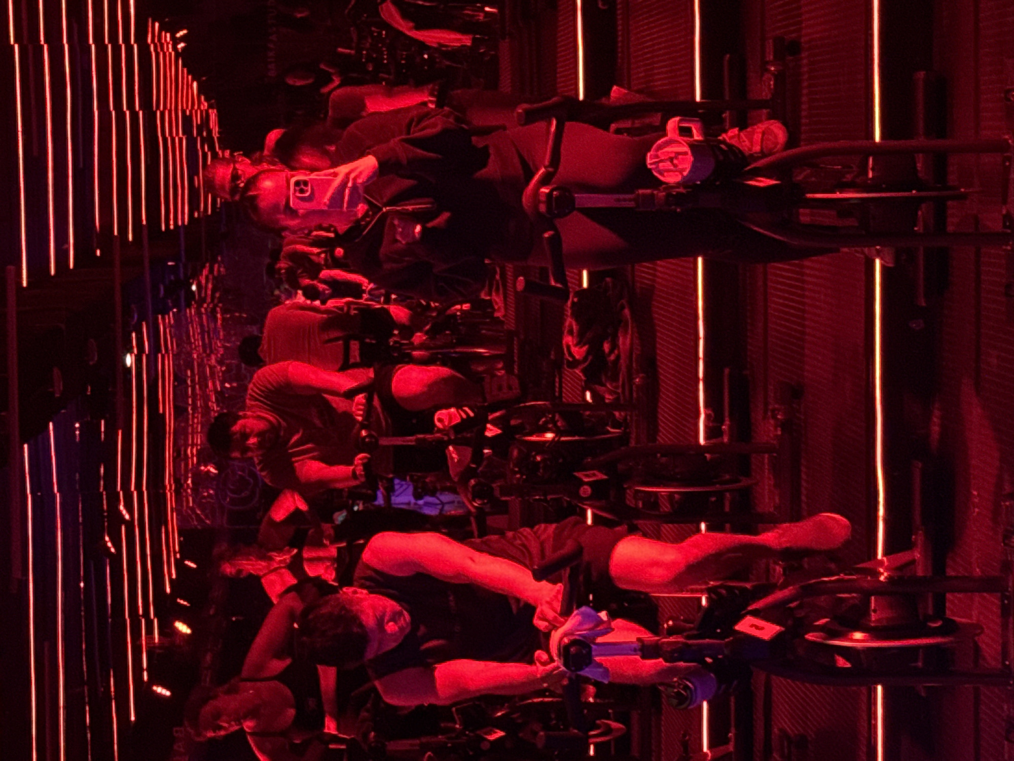 Indoor cycling class under red neon lights in Puebla