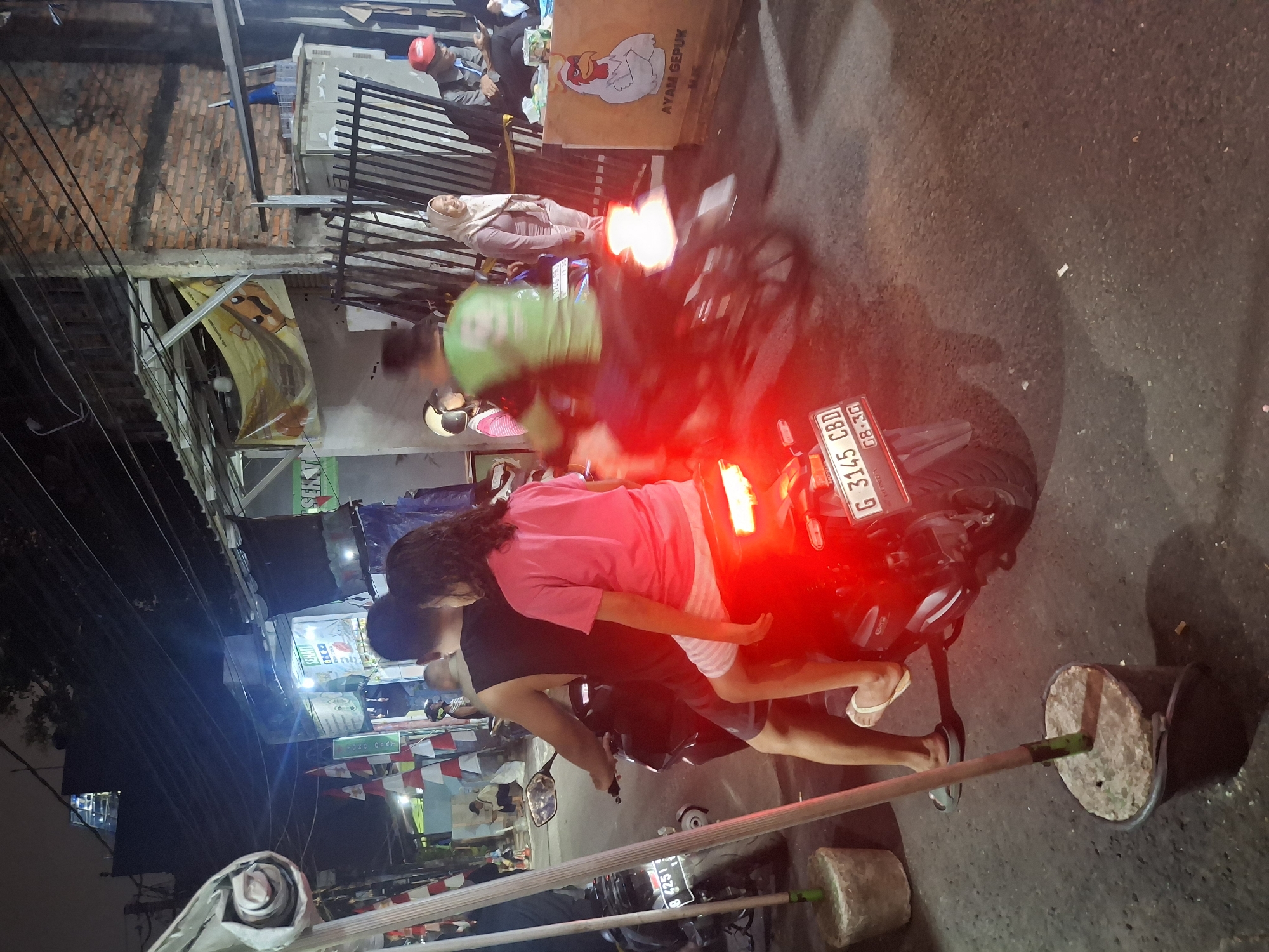 South Jakarta street at night — bikes, shops, and local activity