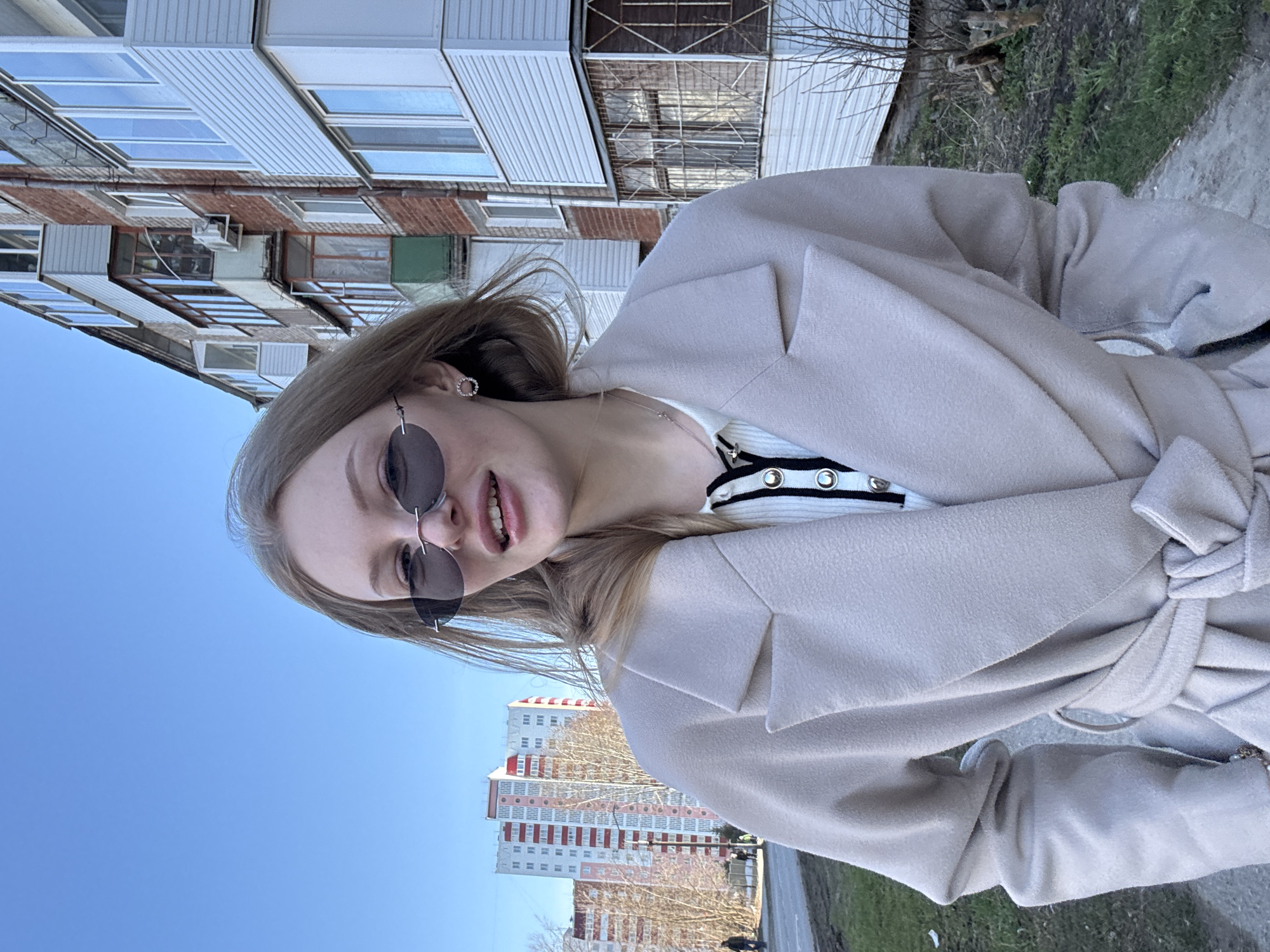 Woman takes outdoor selfies in Perm on sunny spring day