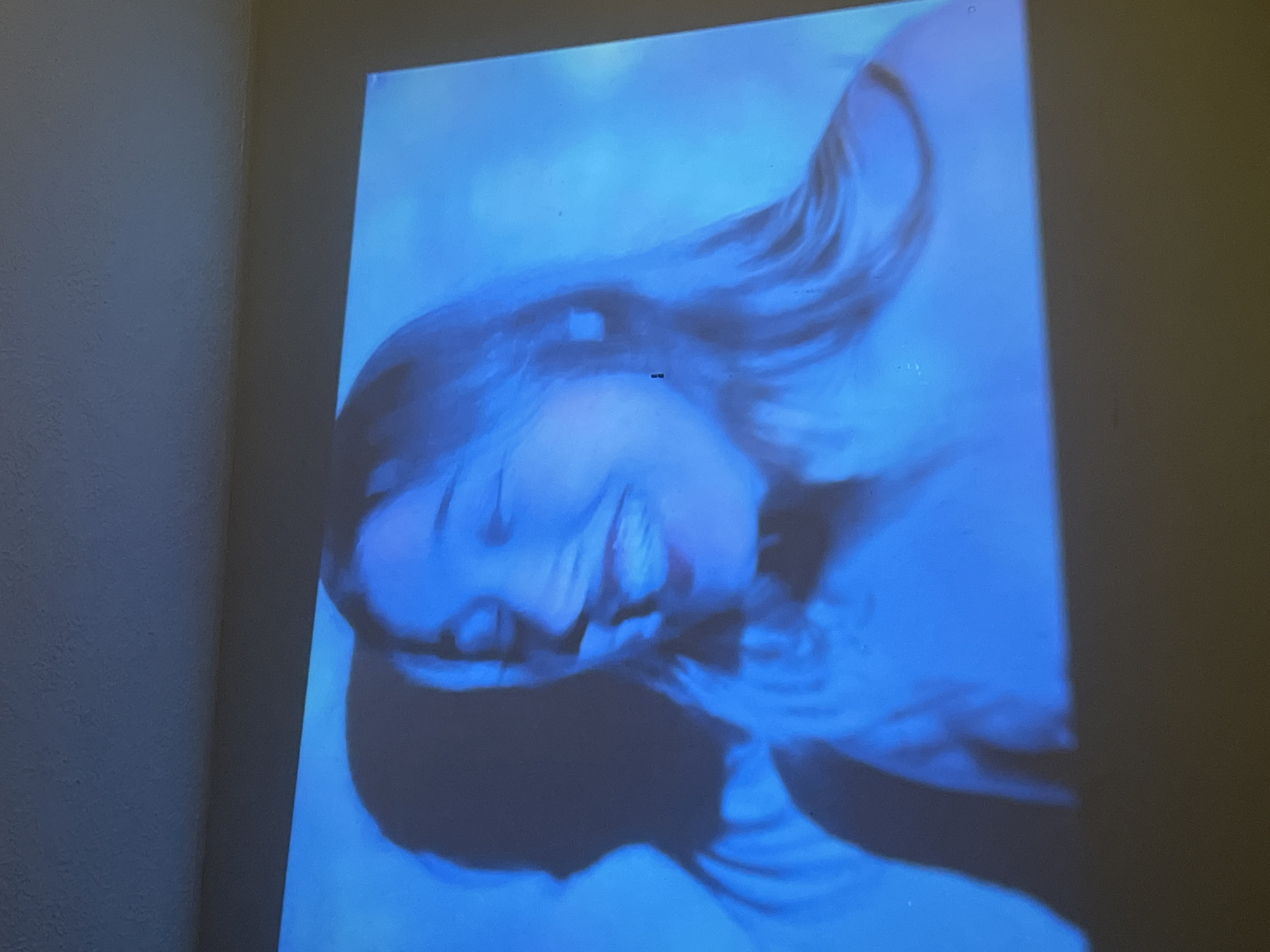 Blue-toned woman's portrait projected on walls in Maidstone home