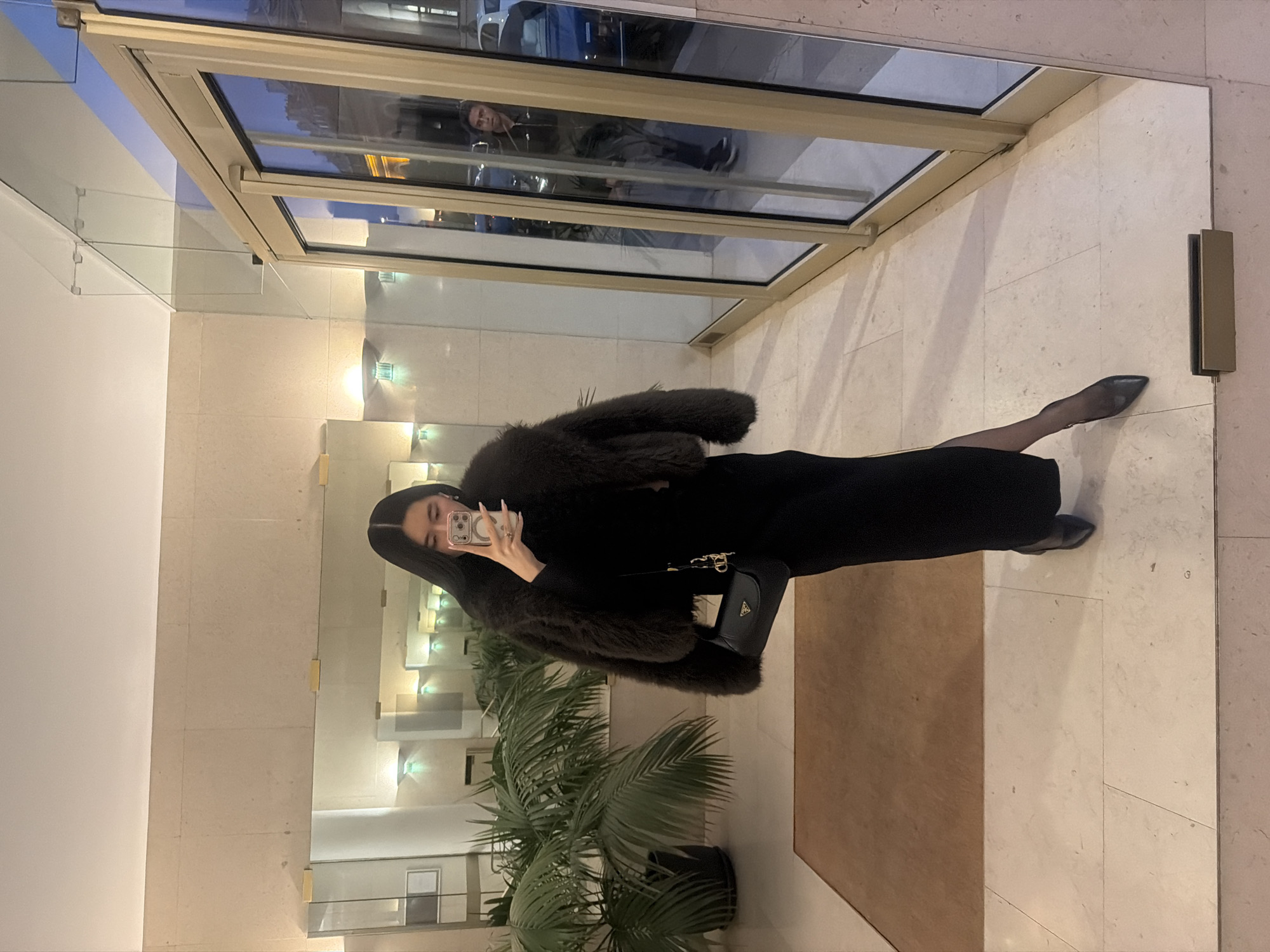 Woman takes selfies in Parisian building elevator and lobby