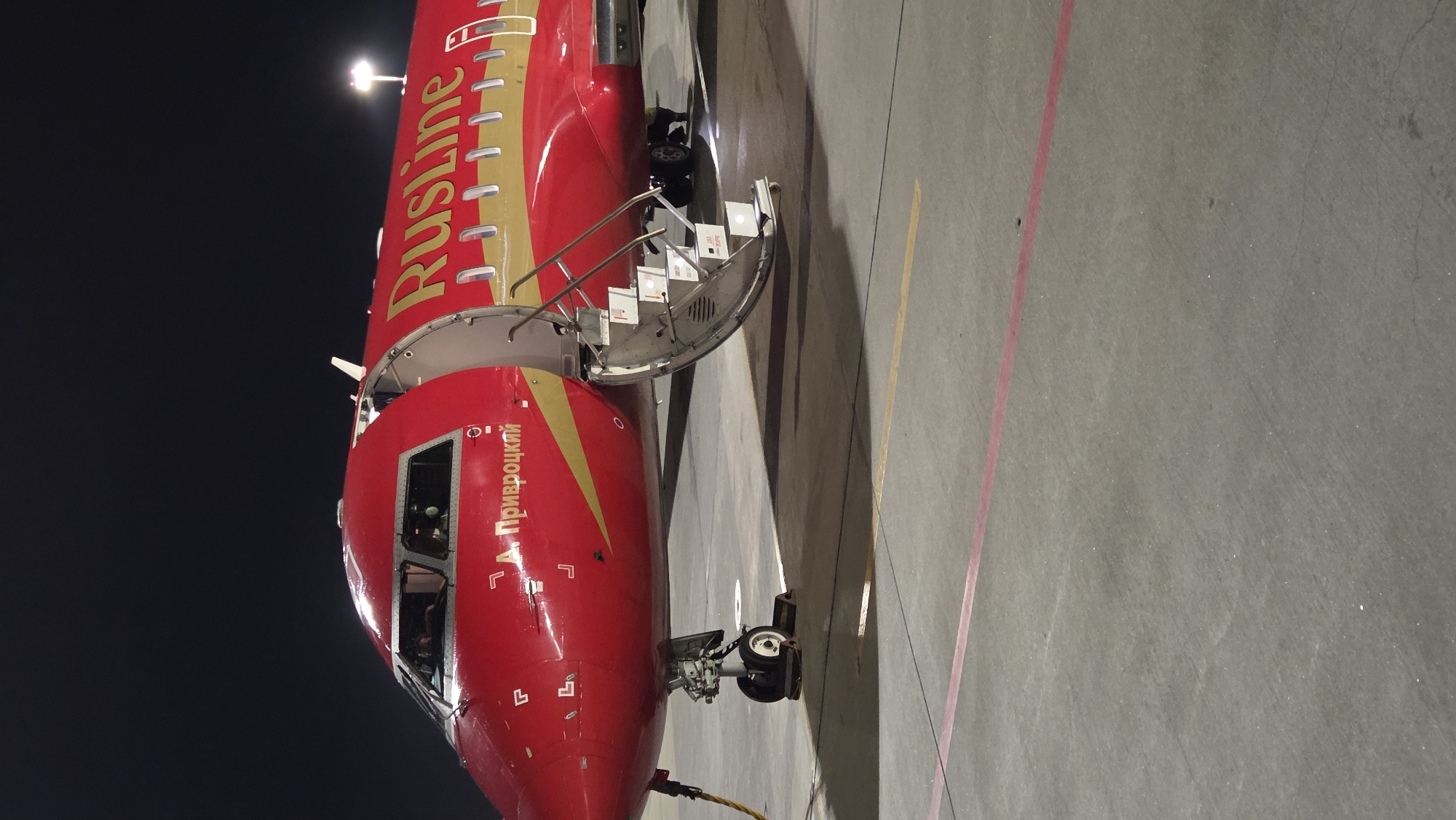 RusLine jet on the tarmac, Saint Petersburg glowing below at night