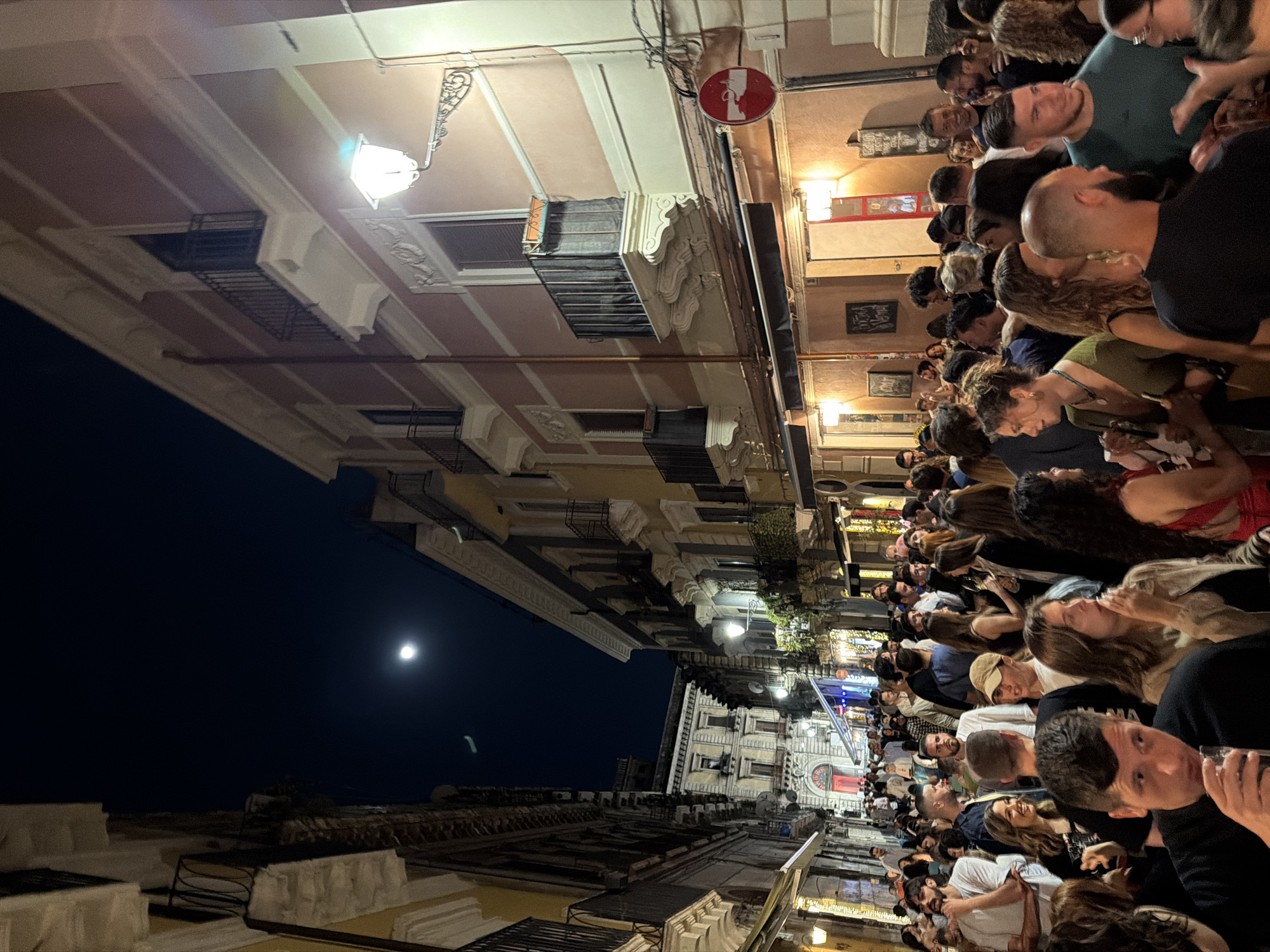 Evening crowds gather on narrow Catania street for dining