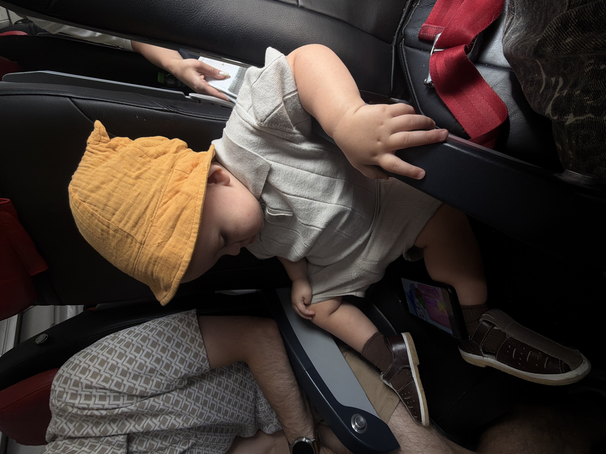 Toddler in orange hat sleeps across airplane seats in Russia