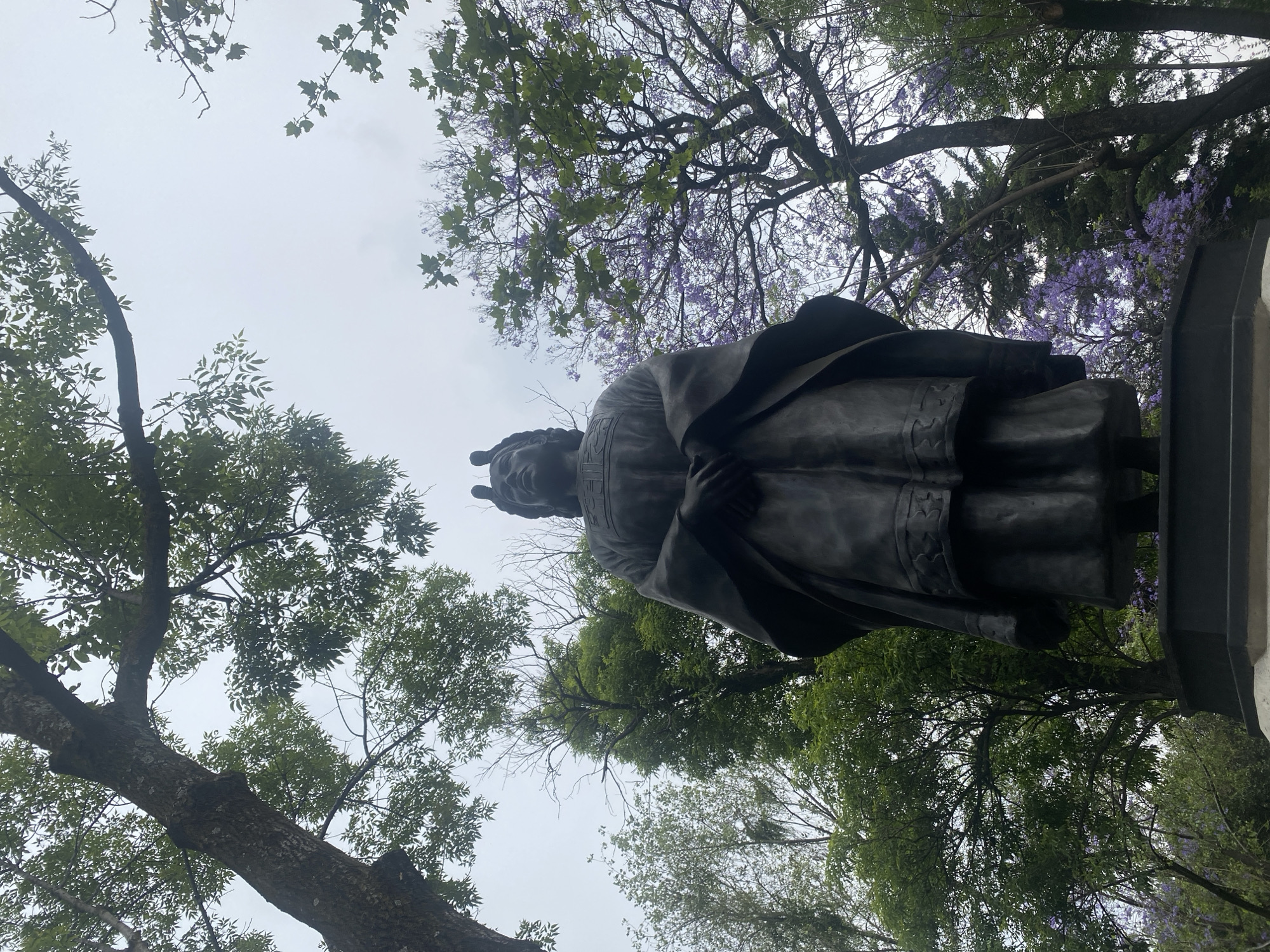 Bronze statue surrounded by blooming trees observed in Mexico City