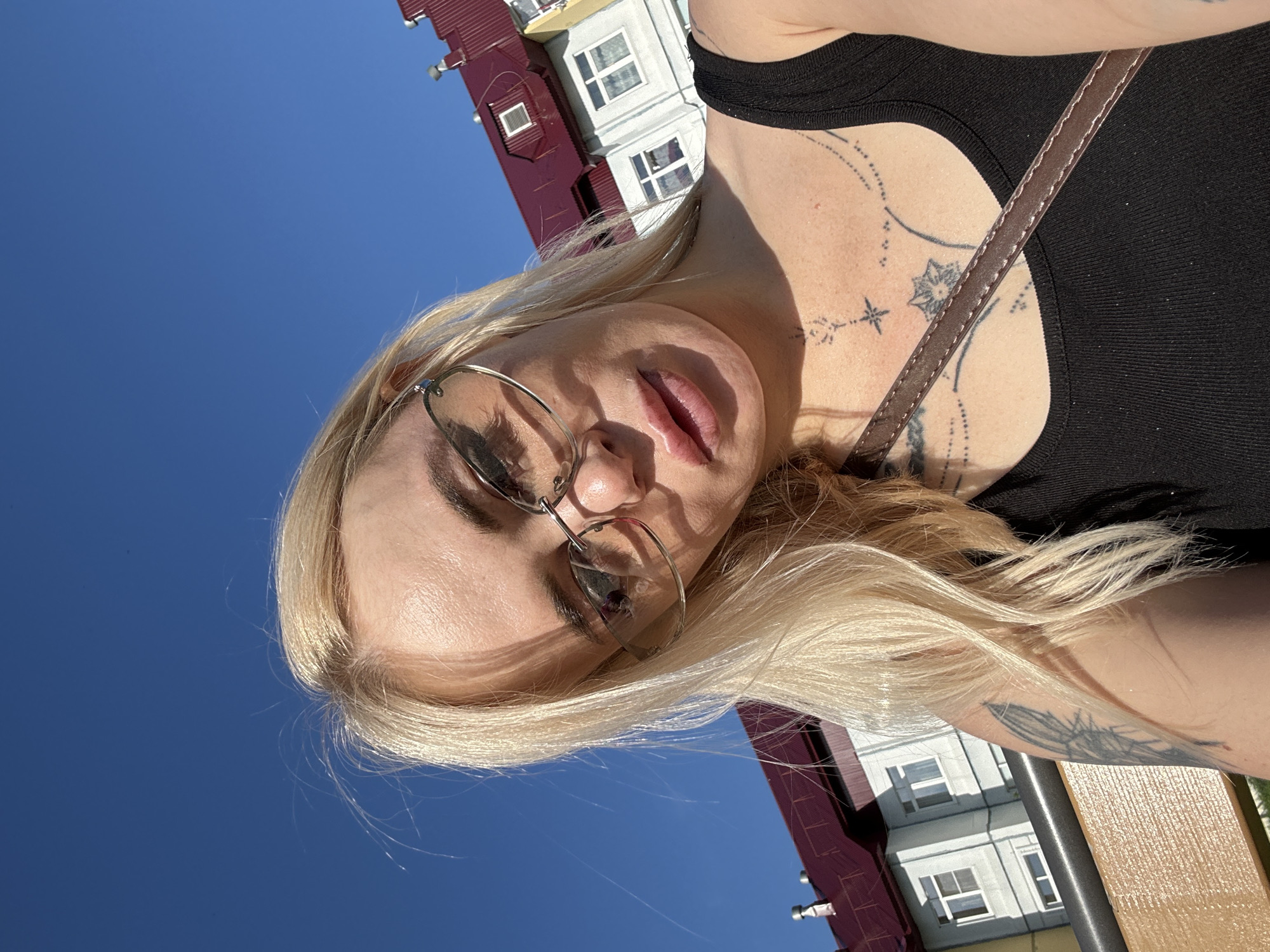 Woman takes selfies near colorful building during midday break