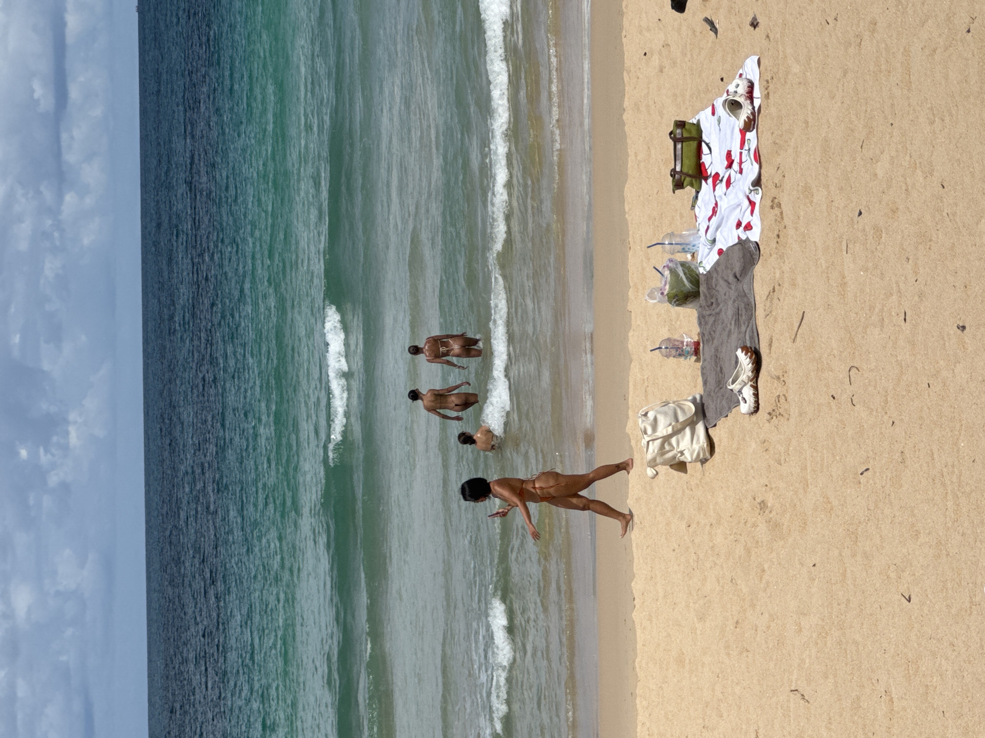 Quiet beach day in Rawai, swimmers and sunbathers along the shore