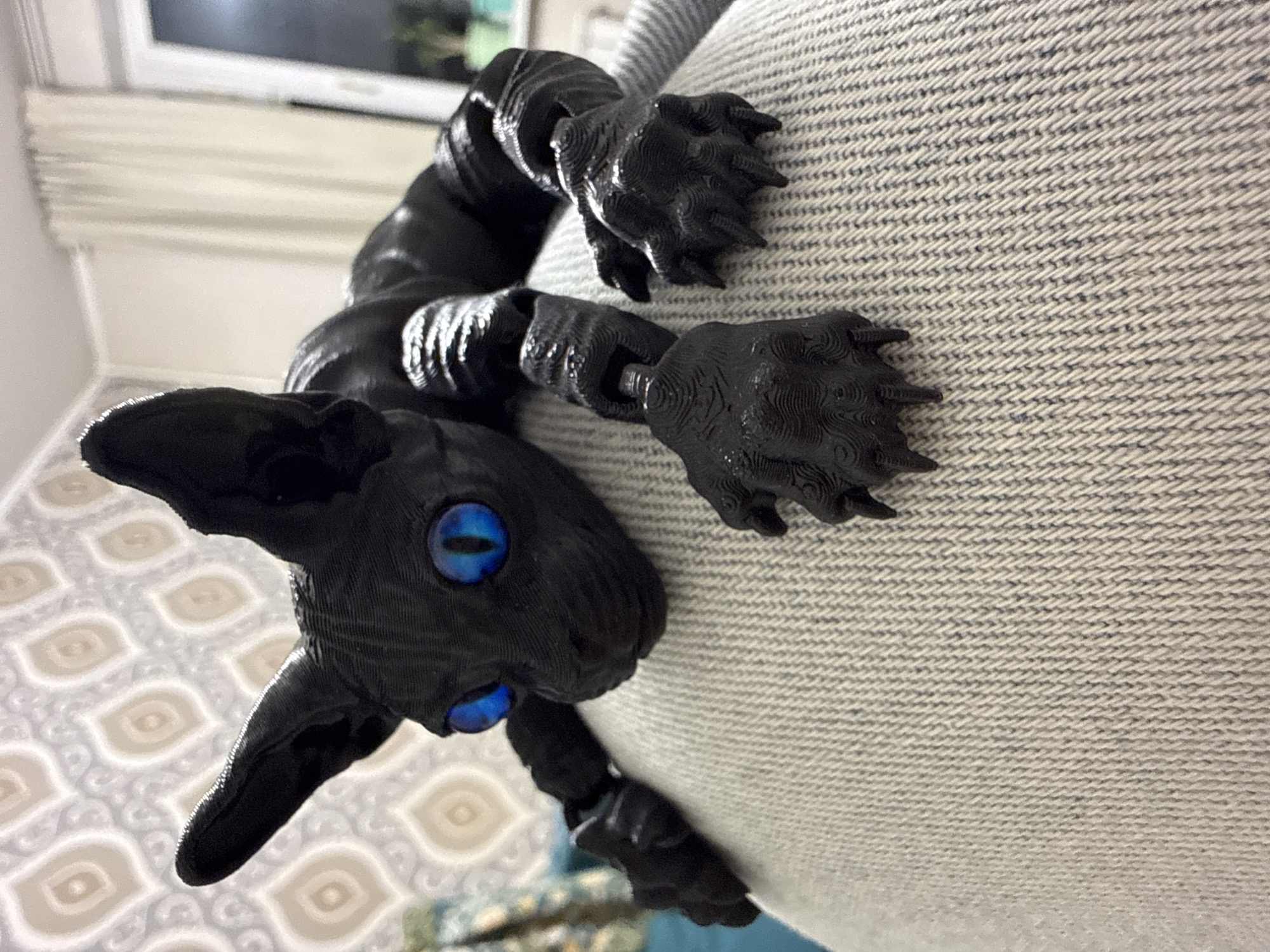 Black cat figurine photographed on furniture in Khimki apartment
