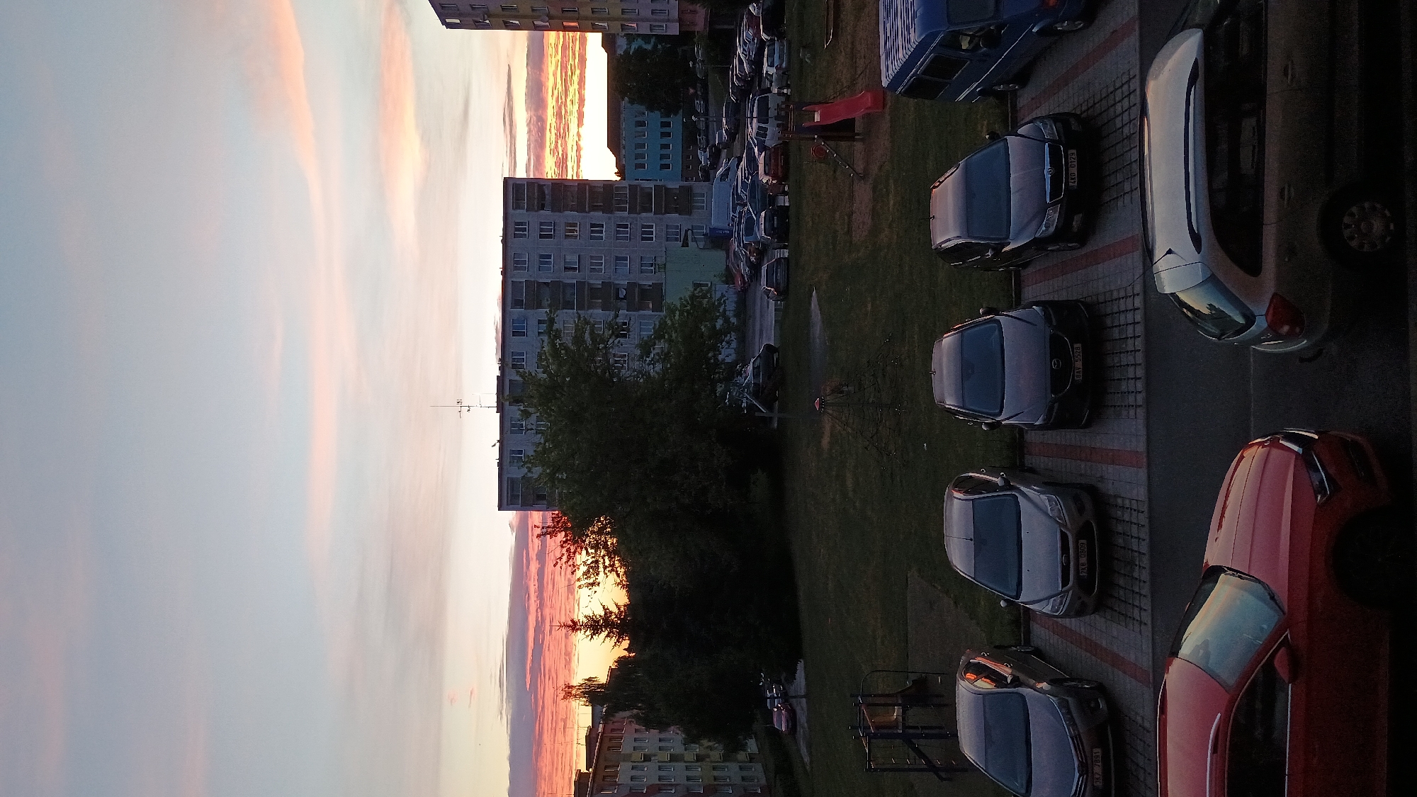 Sunset over Sokolov rooftops, framed by windowsill plants
