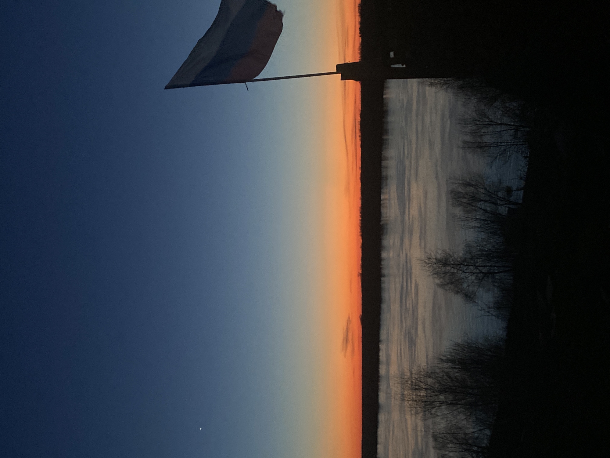 Twilight landscape observed in Ольховка, Russia with flag and water