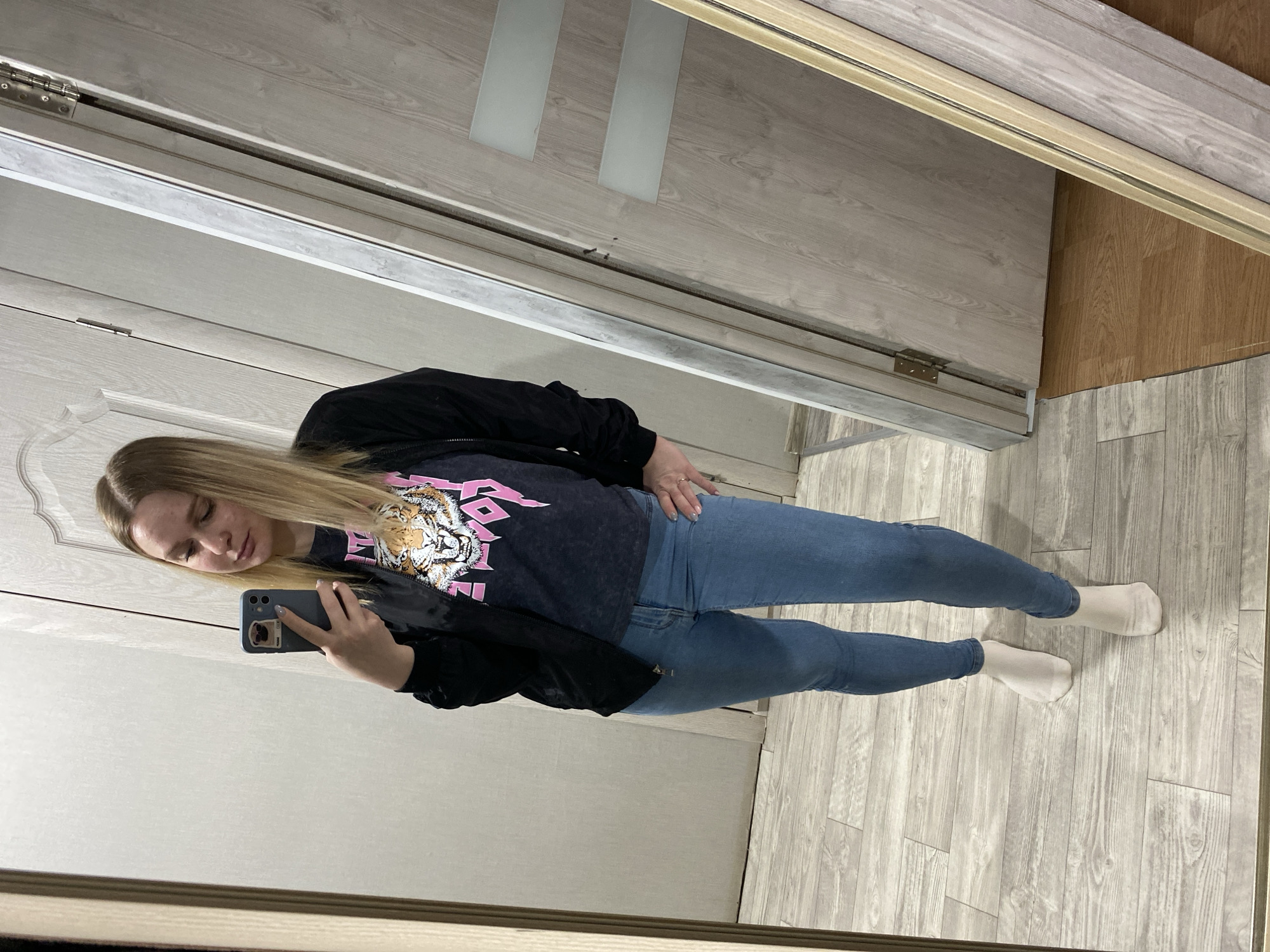 Woman takes mirror selfies in tiger graphic shirt