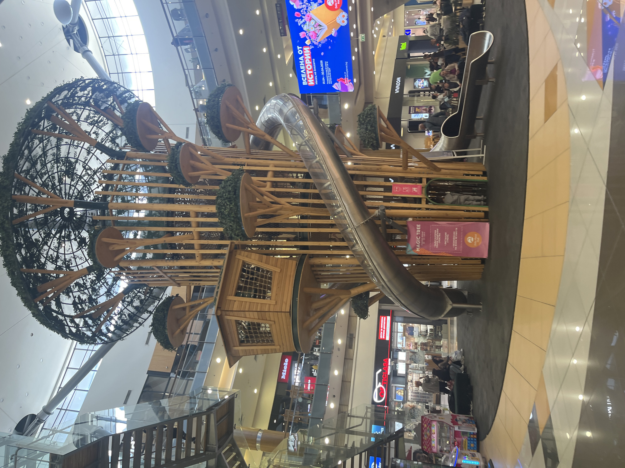 Shopping mall indoor playground with wooden structure and slide observed