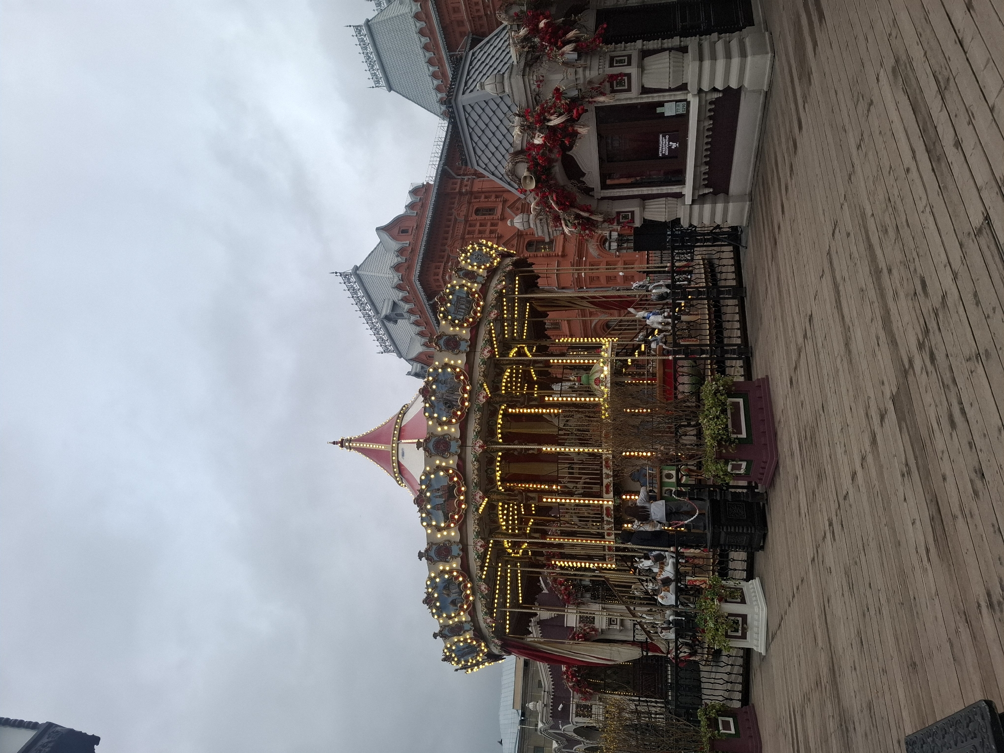 Illuminated carousel operates in Moscow square amid overcast afternoon