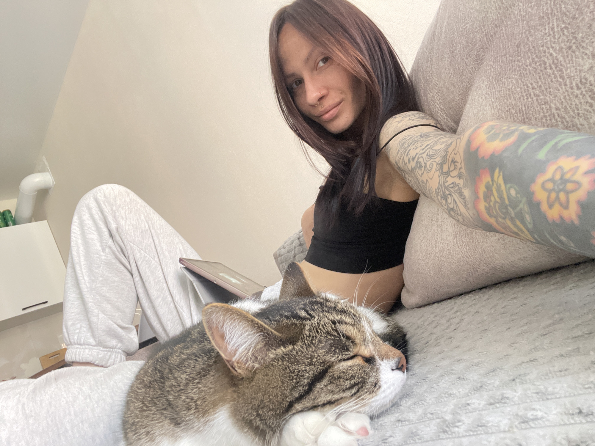 Woman relaxes with sleeping cat on sofa in Izhevsk