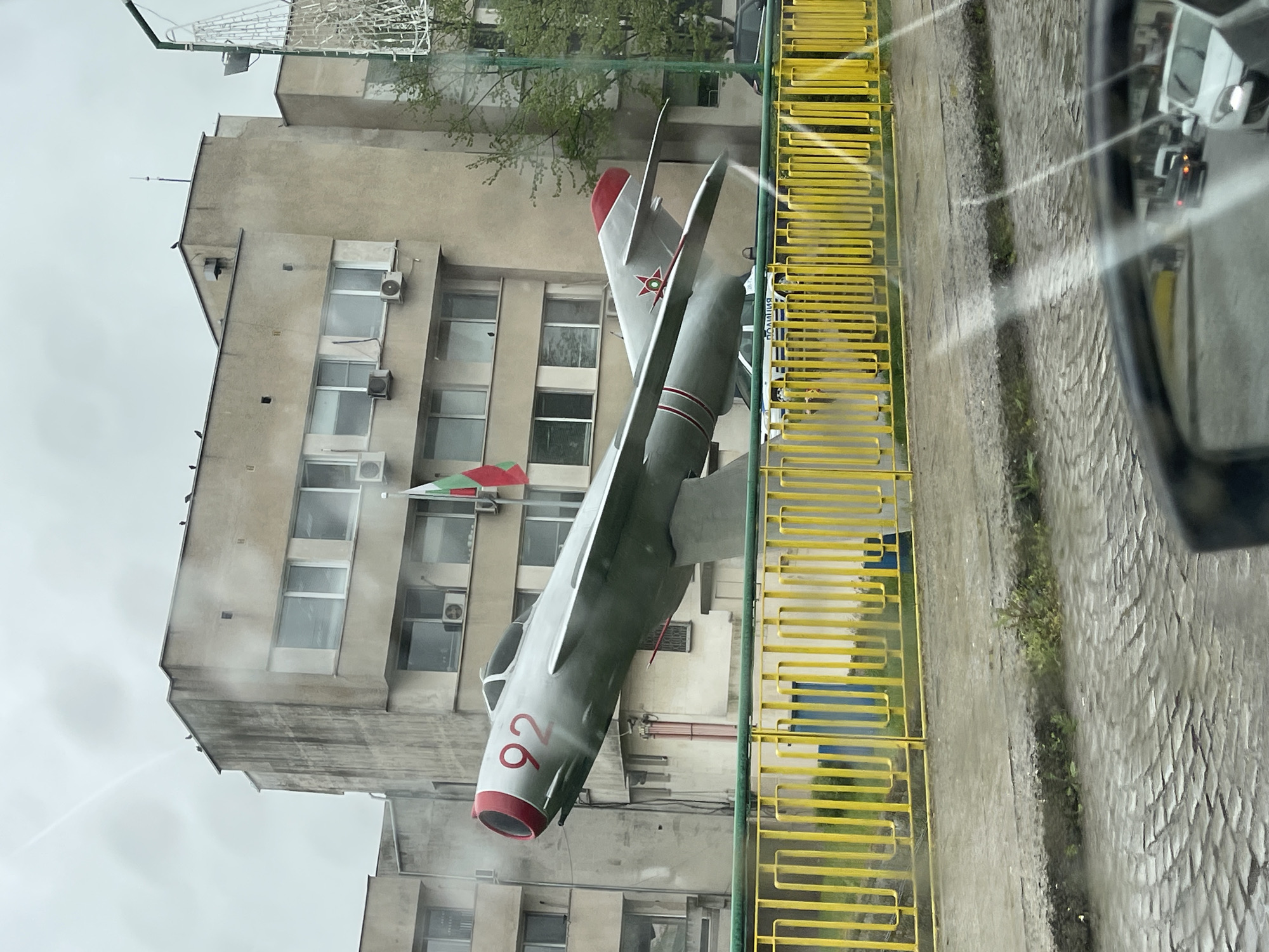 Fighter jet monument displayed on sidewalk in Yambol, Bulgaria