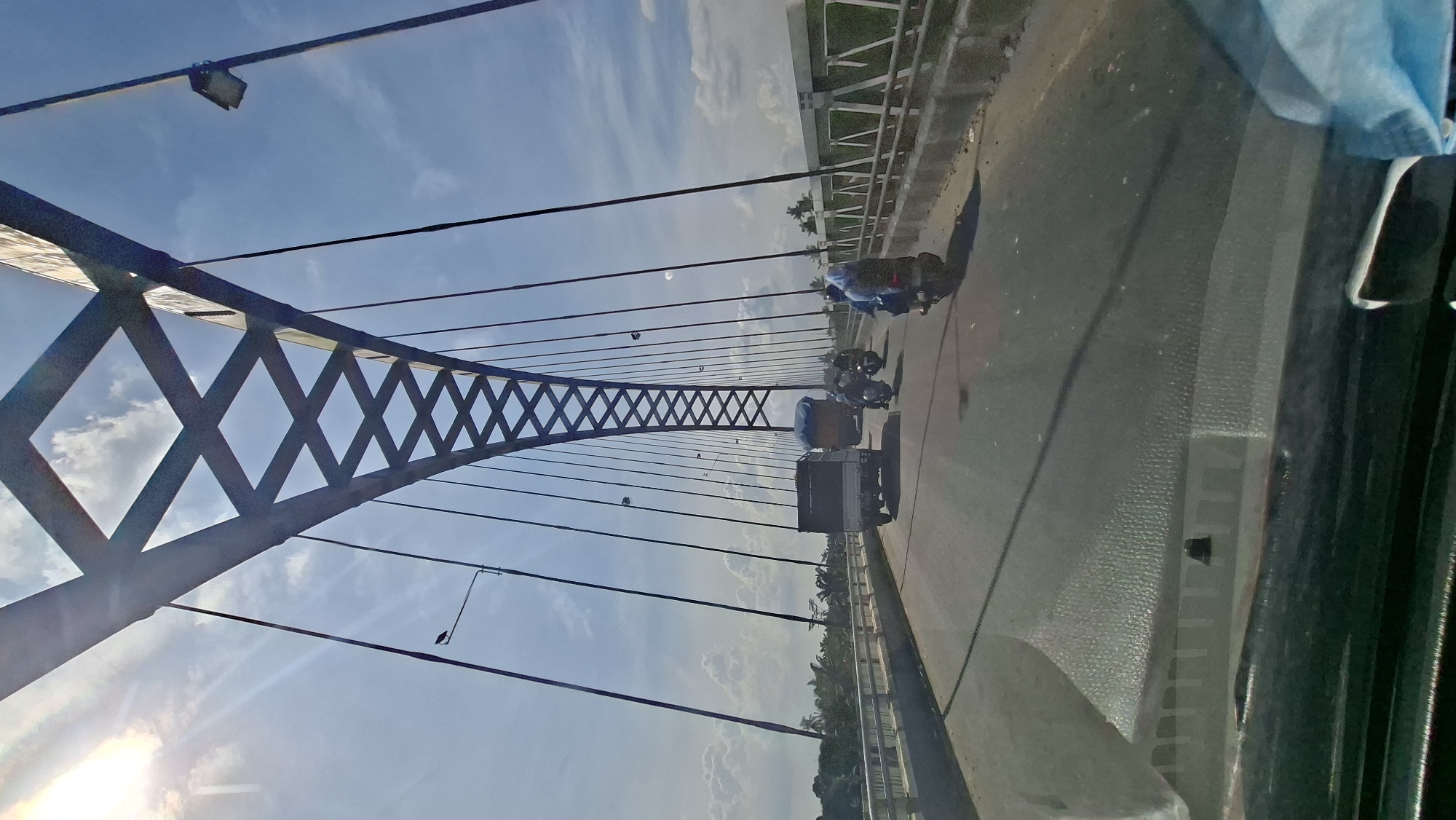 Driving across Stabat's arched cable bridge in light traffic