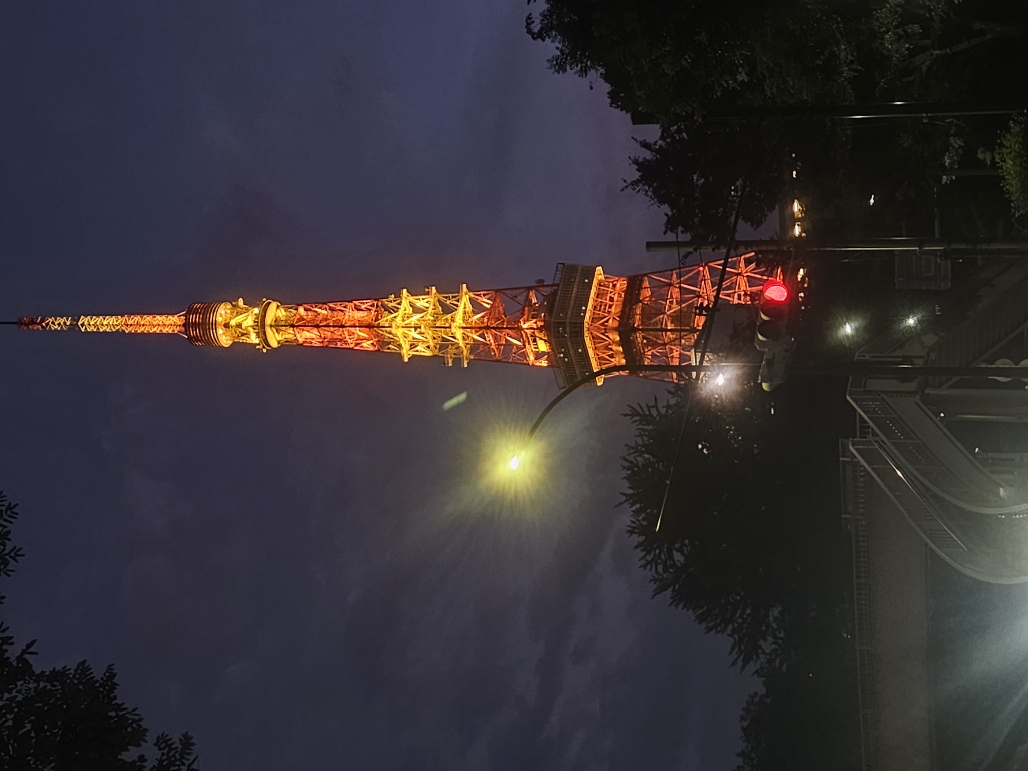 Tokyo Tower glows orange-yellow against twilight skies in Minato