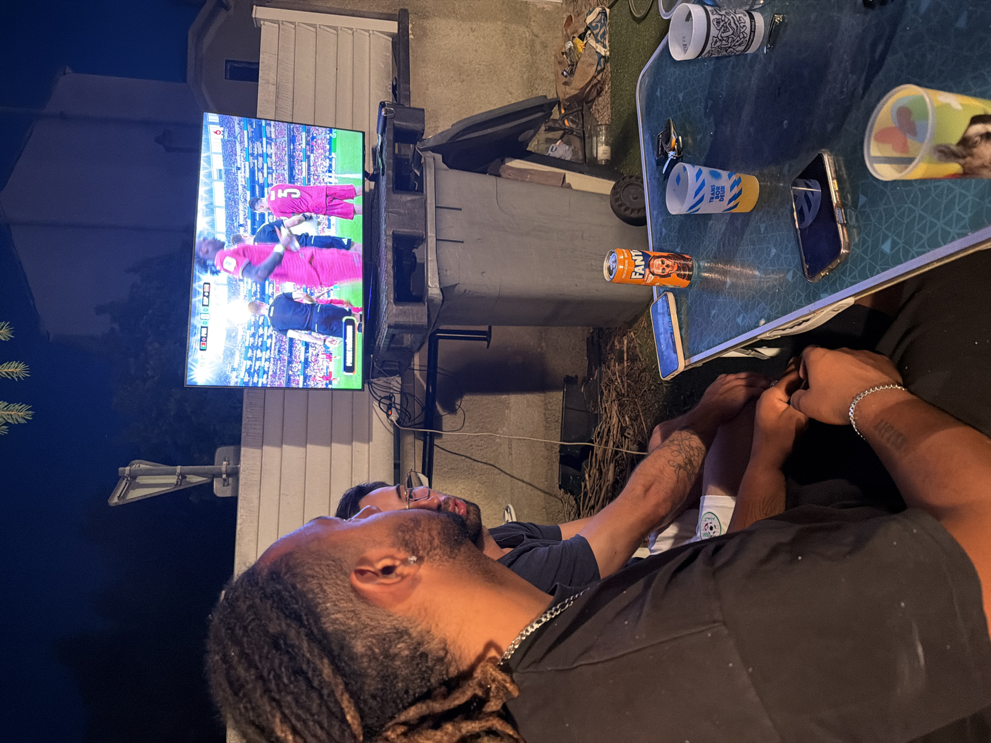 Outdoor soccer watch party on a Villeurbanne patio at dusk