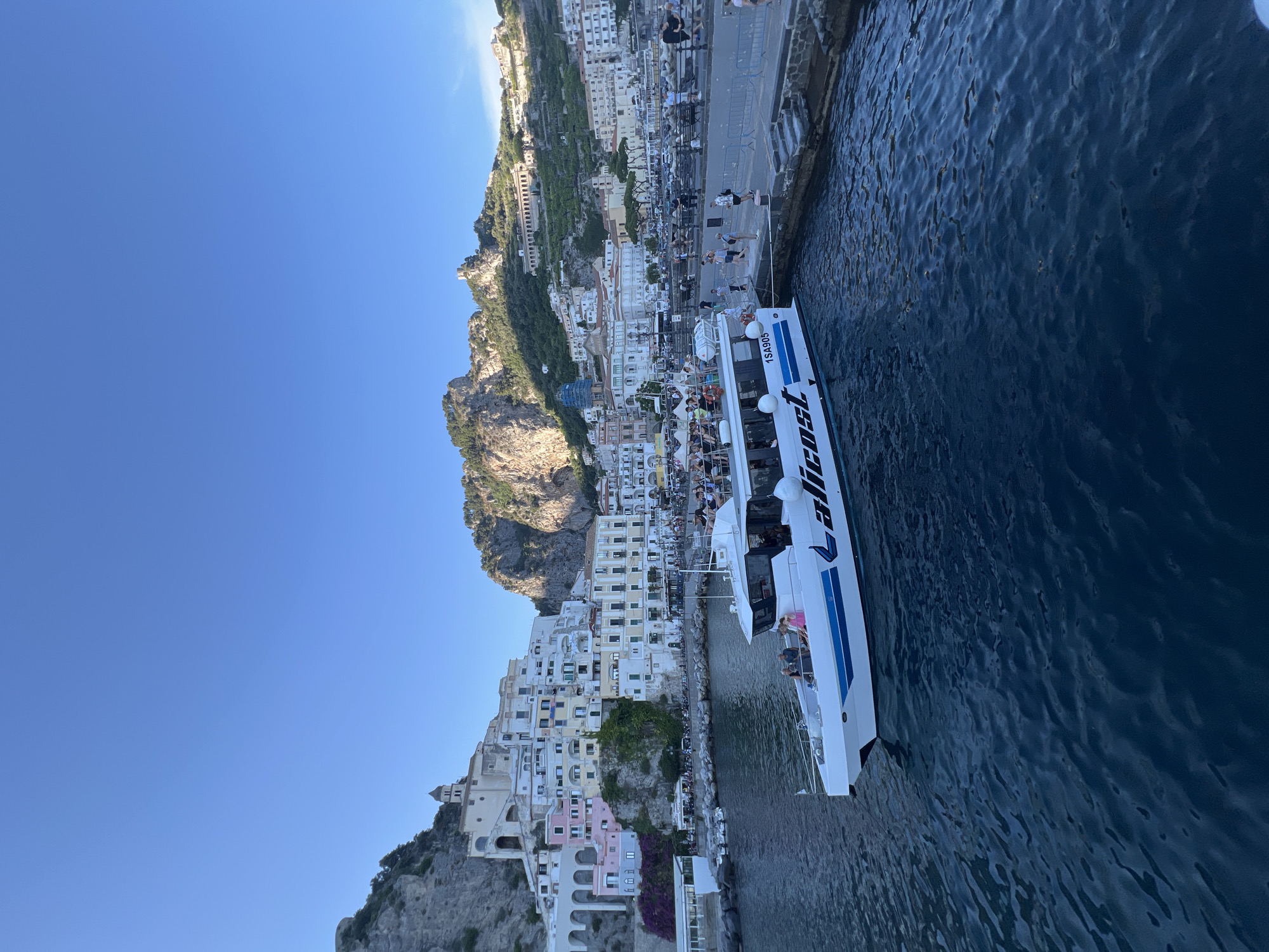 Ferry docks with passengers in Pogerola, Italy