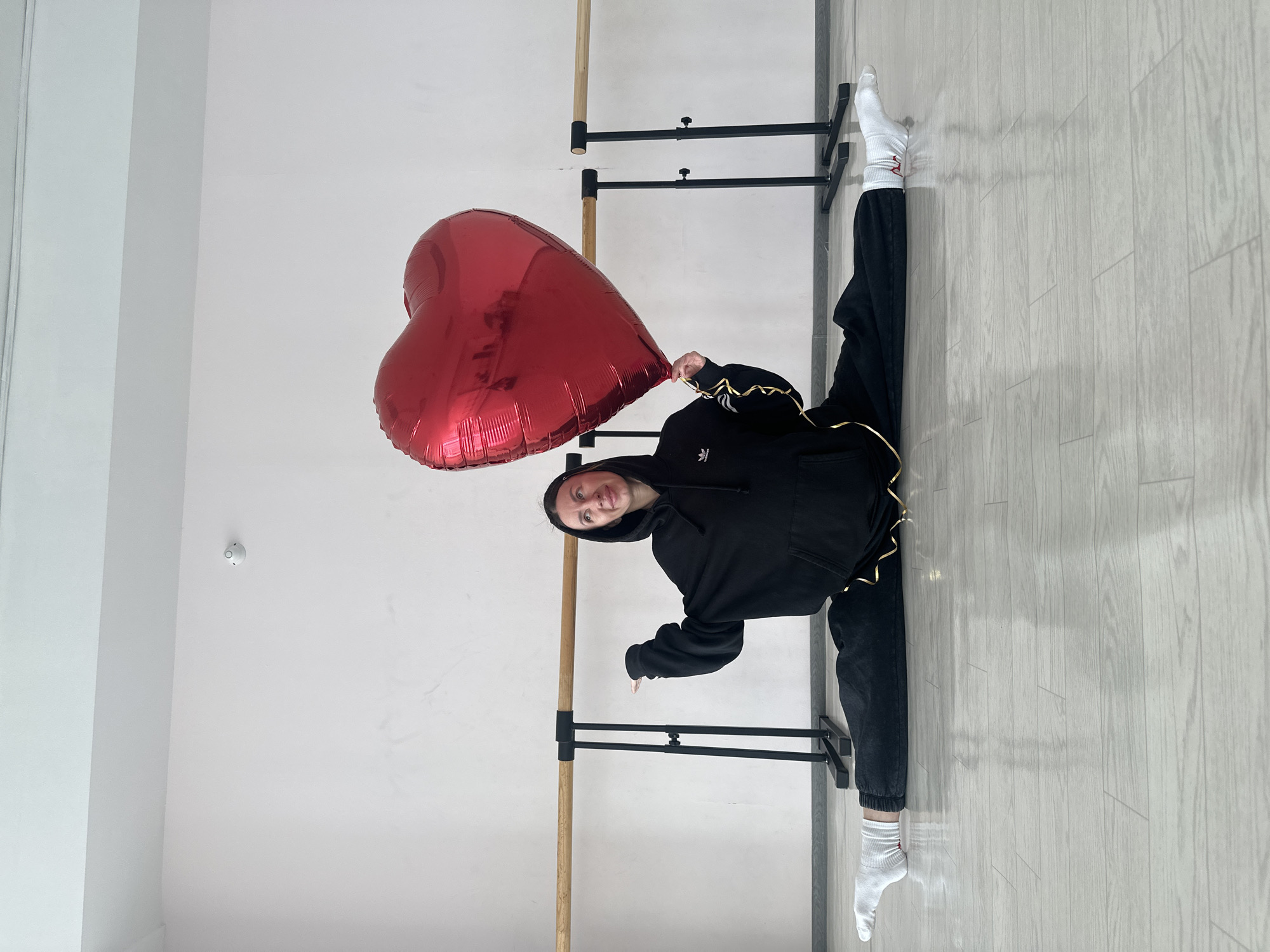 Woman performs acrobatic dance routine with heart balloon in Russian studio