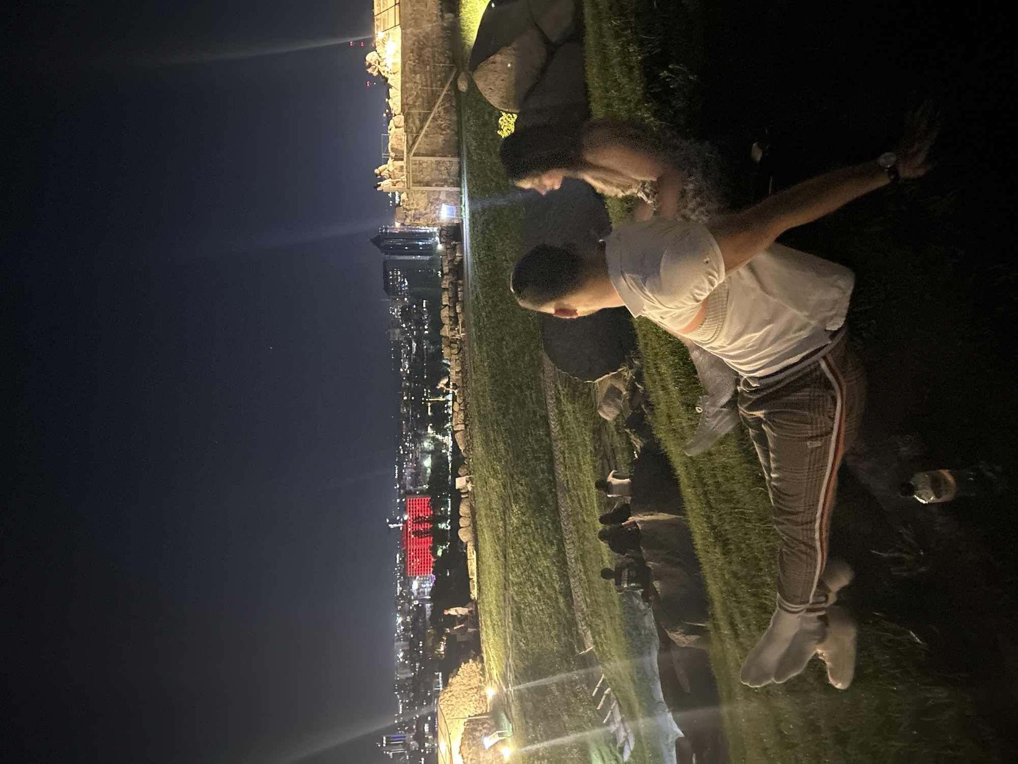 Evening gathering overlooks illuminated Plovdiv cityscape from hillside vantage point