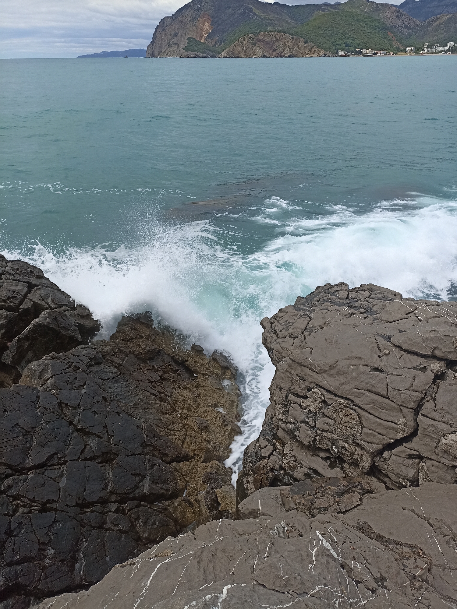 Waves crash against rocky coastline in Čanj, Montenegro