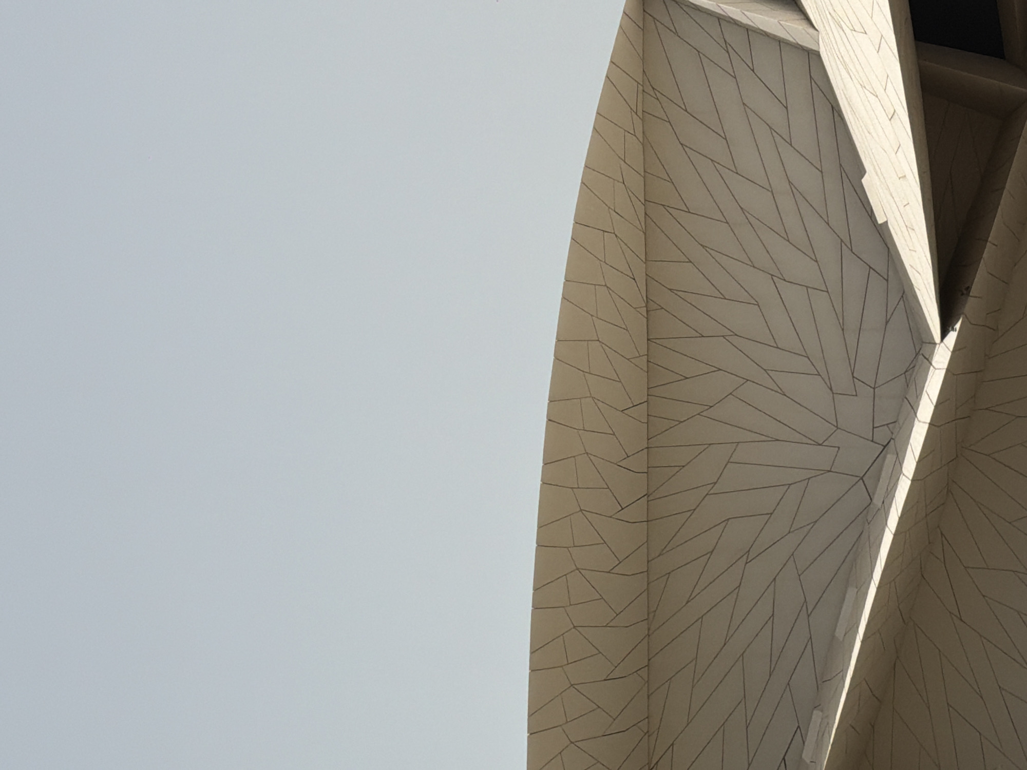 Tourist photographs National Museum of Qatar during morning visit