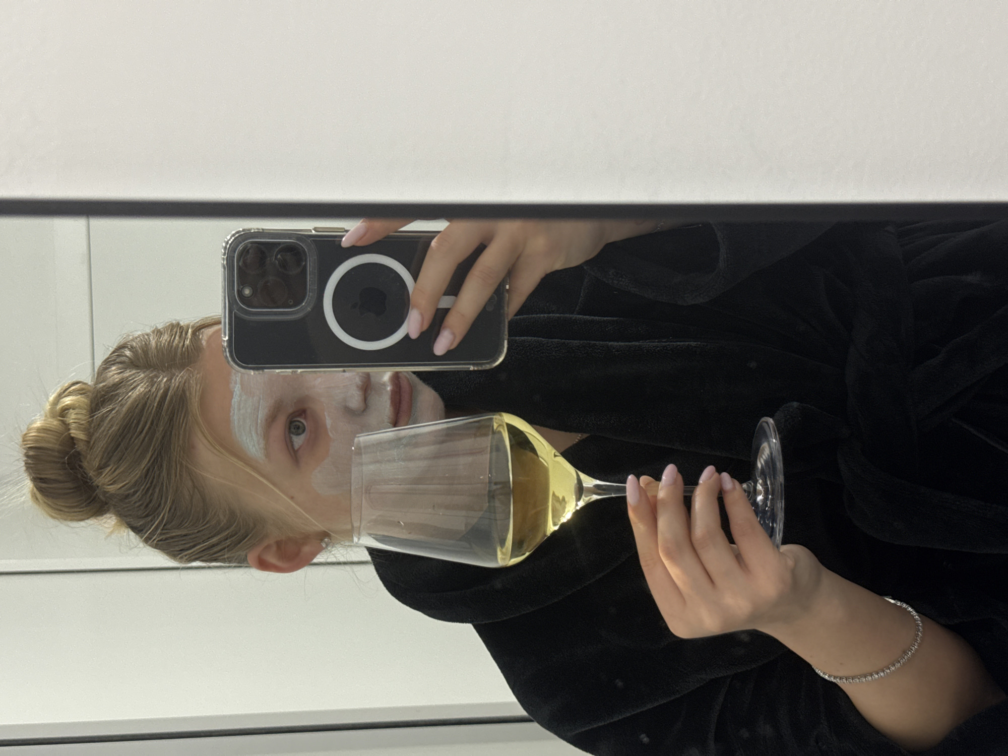 Person documents skincare routine with wine, selfie in Ariel
