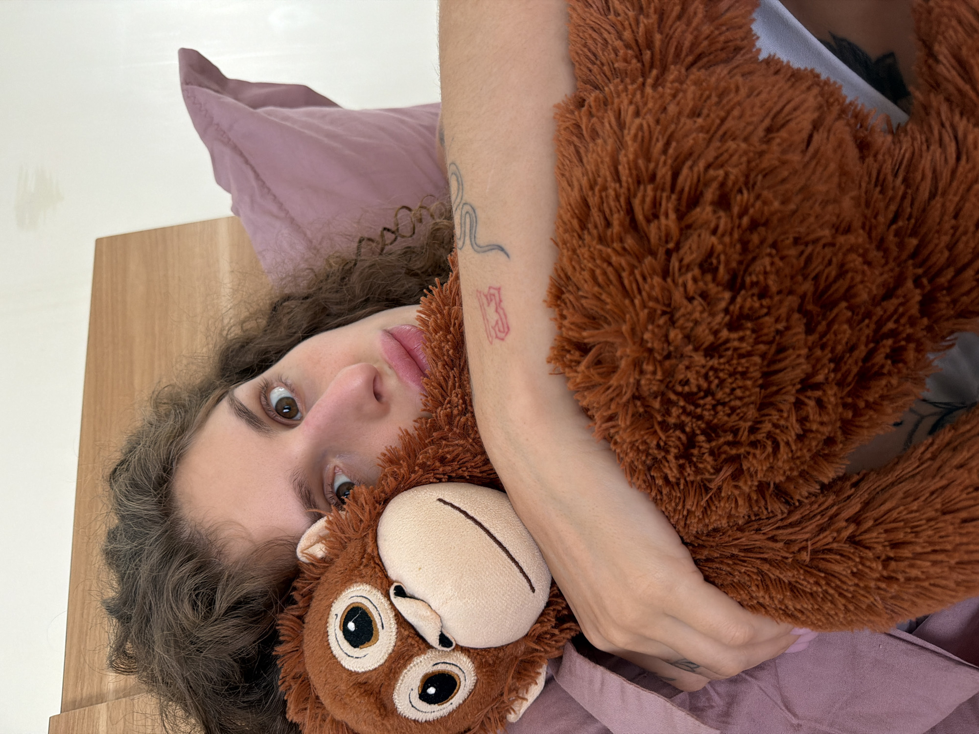 Woman cuddles stuffed monkey in bedroom photos, North Kuta