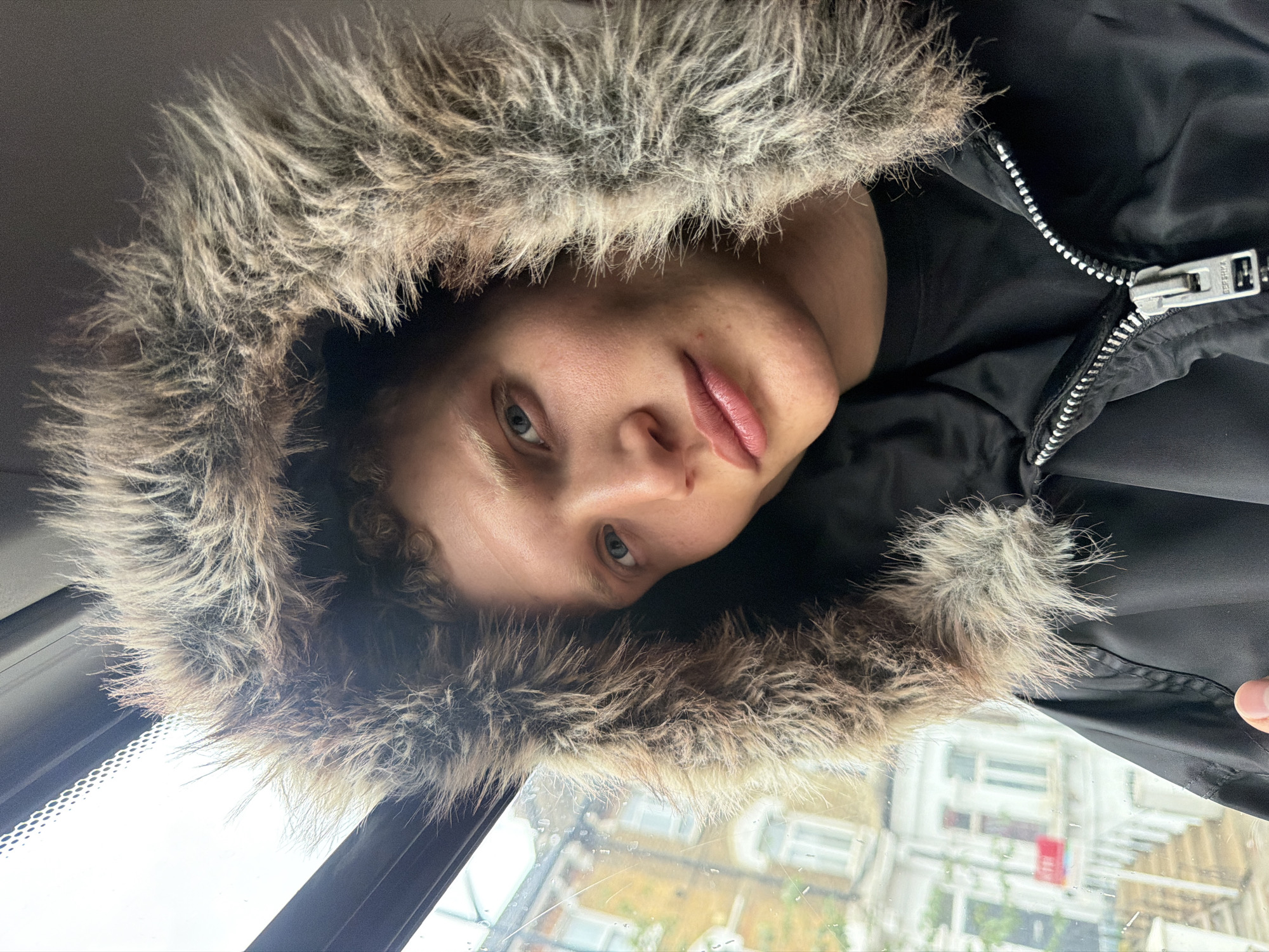 Young person in fur-trimmed hood photographed in London selfie