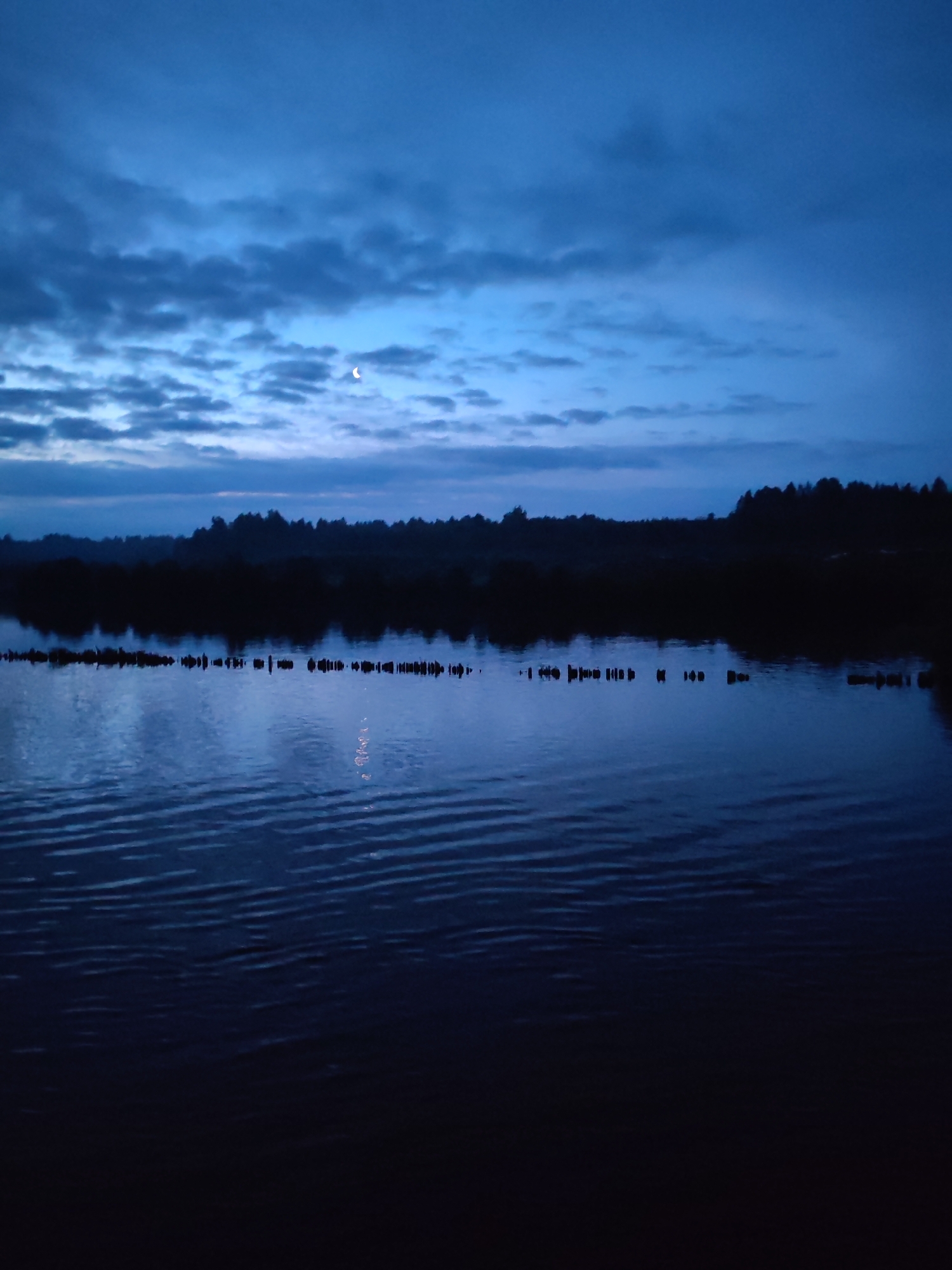 Red cargo ship docked on the Svir River at twilight