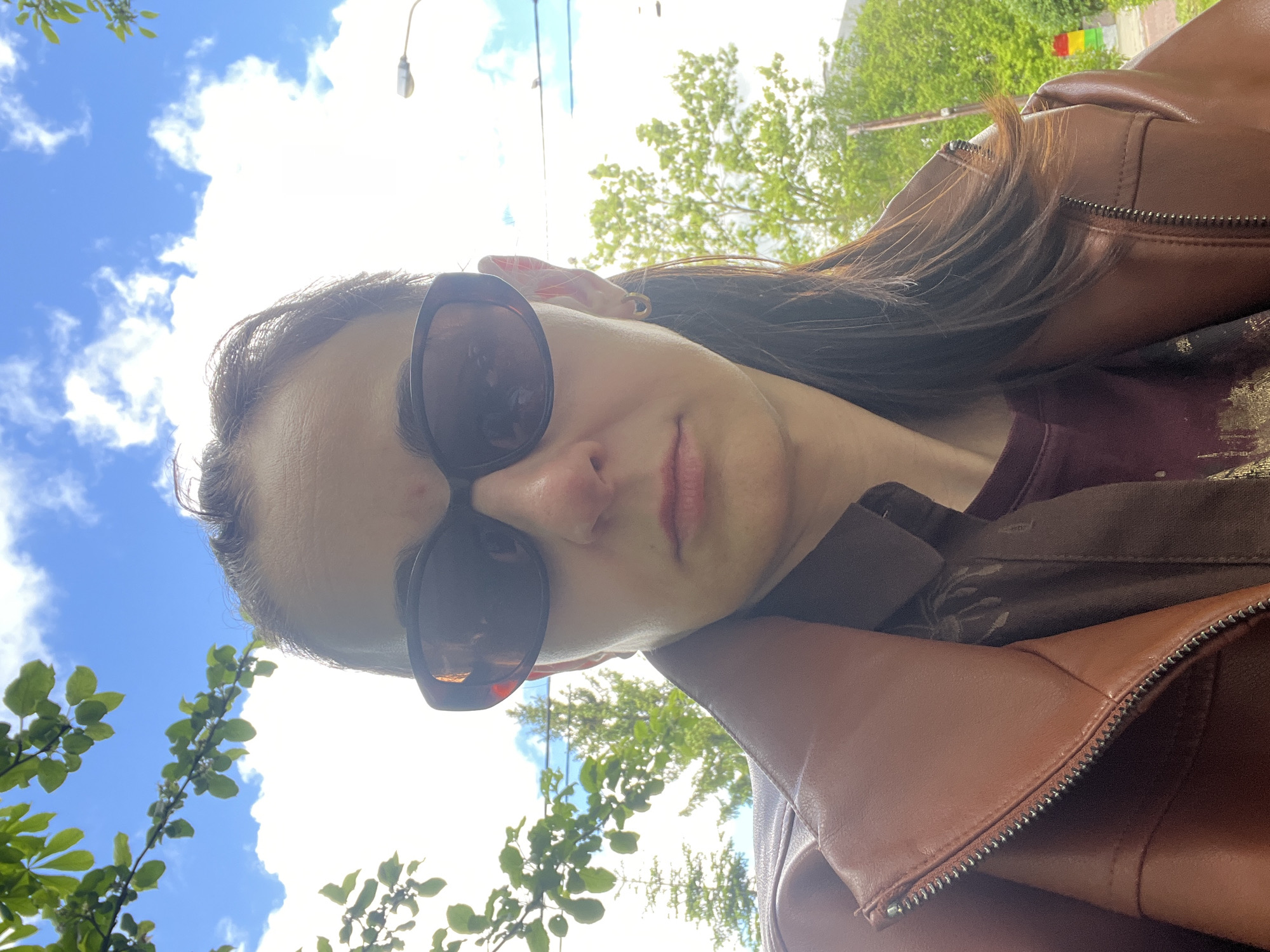 Woman takes selfies while child climbs tree in park