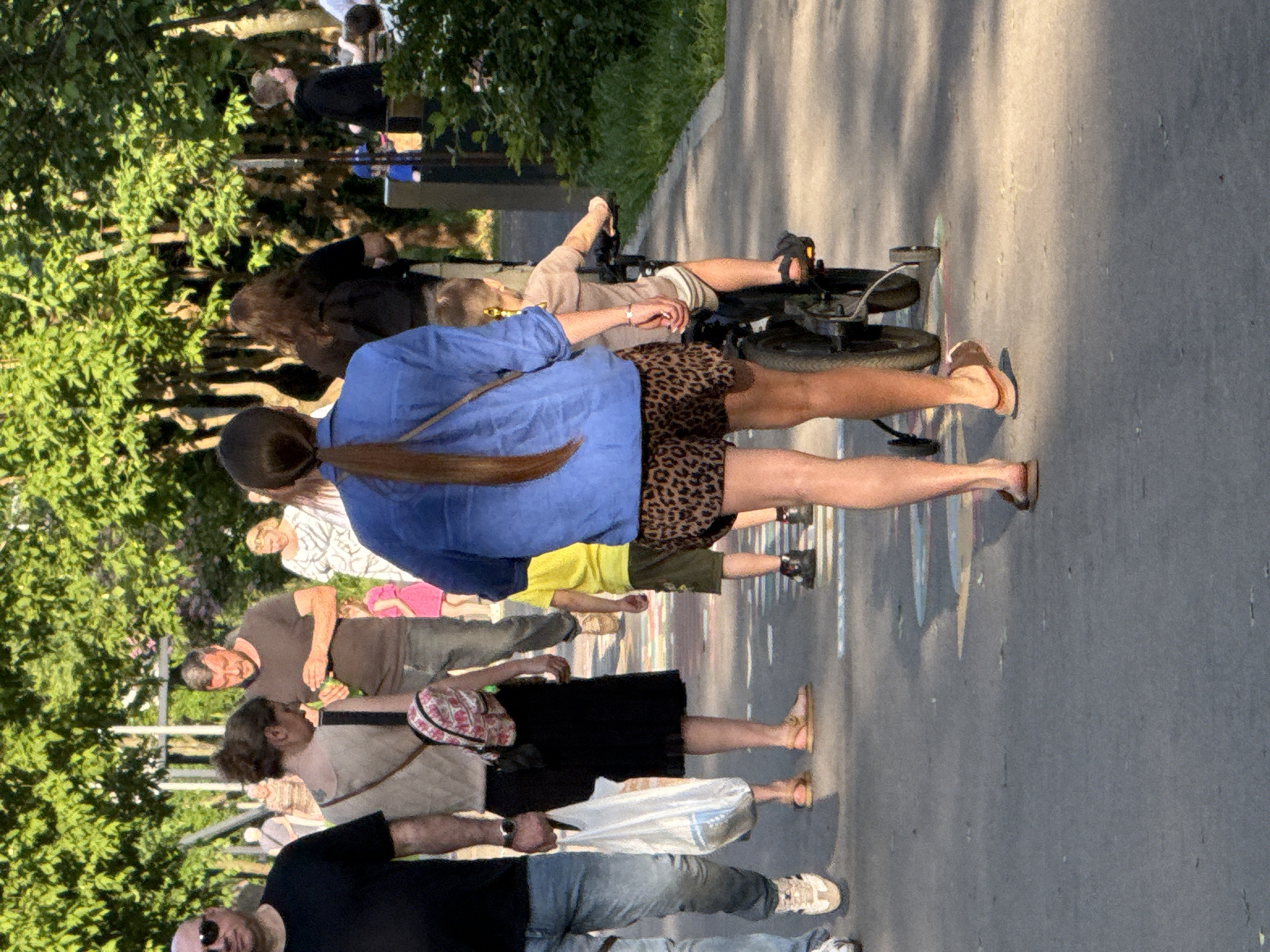 Mixed-age group strolls through Moscow park in summer attire
