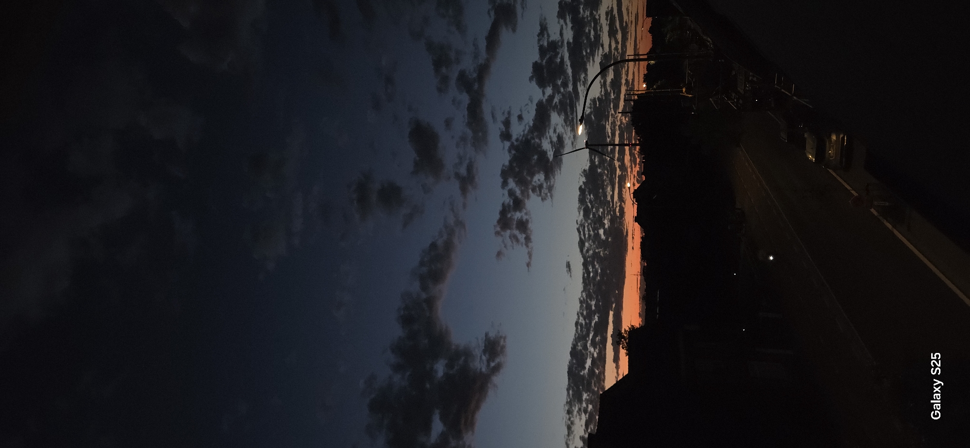 Sunset to twilight: wind turbine and suburban skyline at dusk