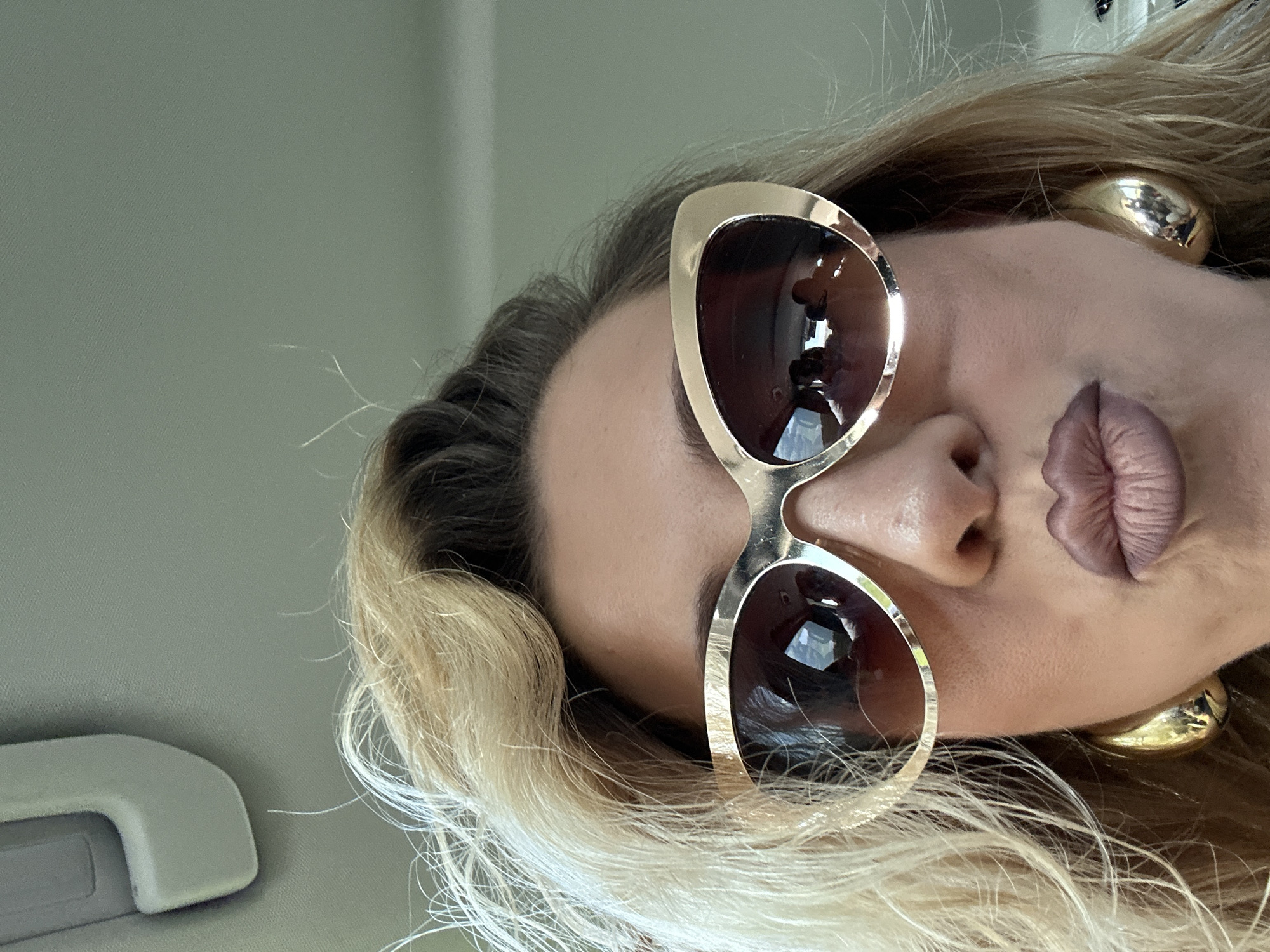Woman takes selfie in Dronten wearing gold-framed sunglasses