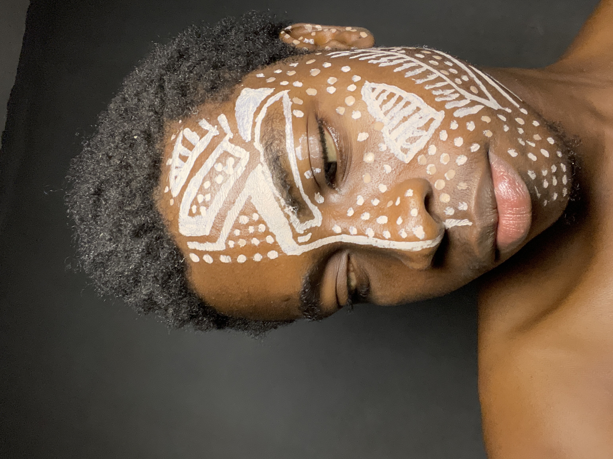 Person displays traditional white tribal face paint in Nkpor