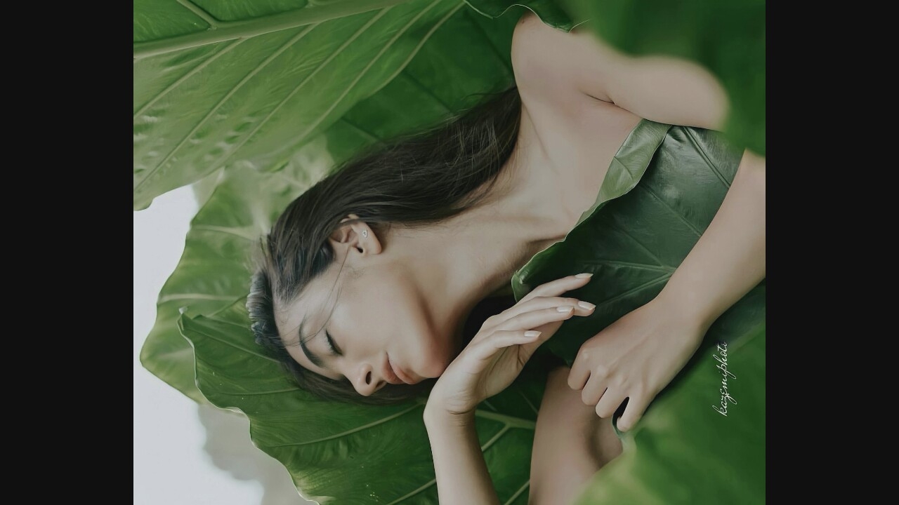 Resting figure nestled peacefully among lush green leaves