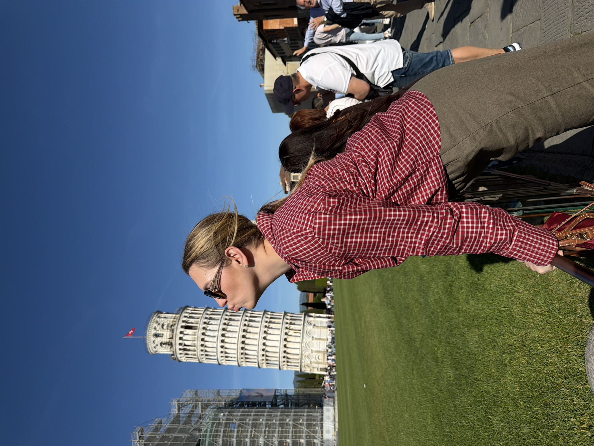 Tourist poses with Leaning Tower during scaffolding work