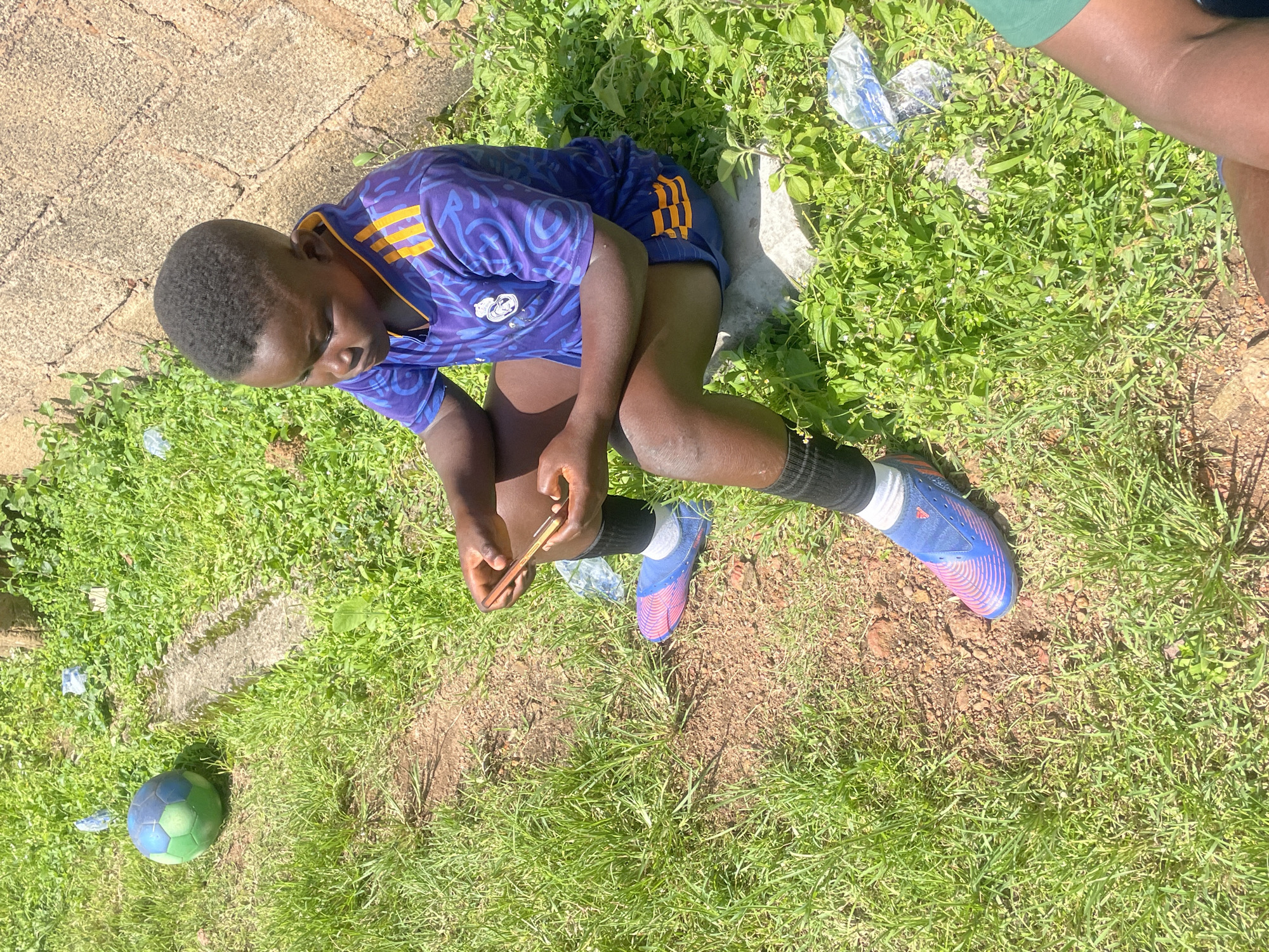 Football crew taking a break on a grassy field in Jos