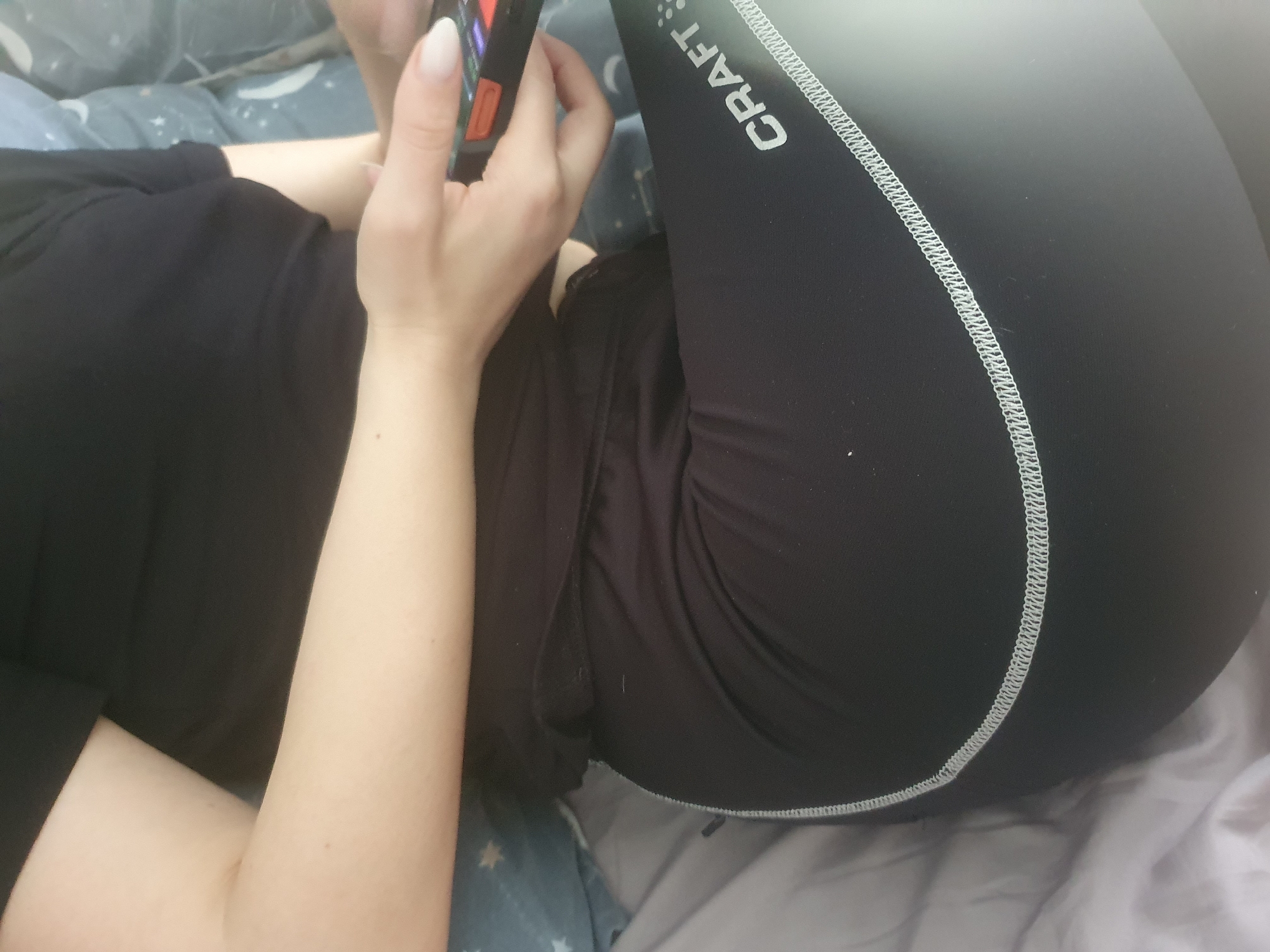 Person uses smartphone on bed in Plovdiv