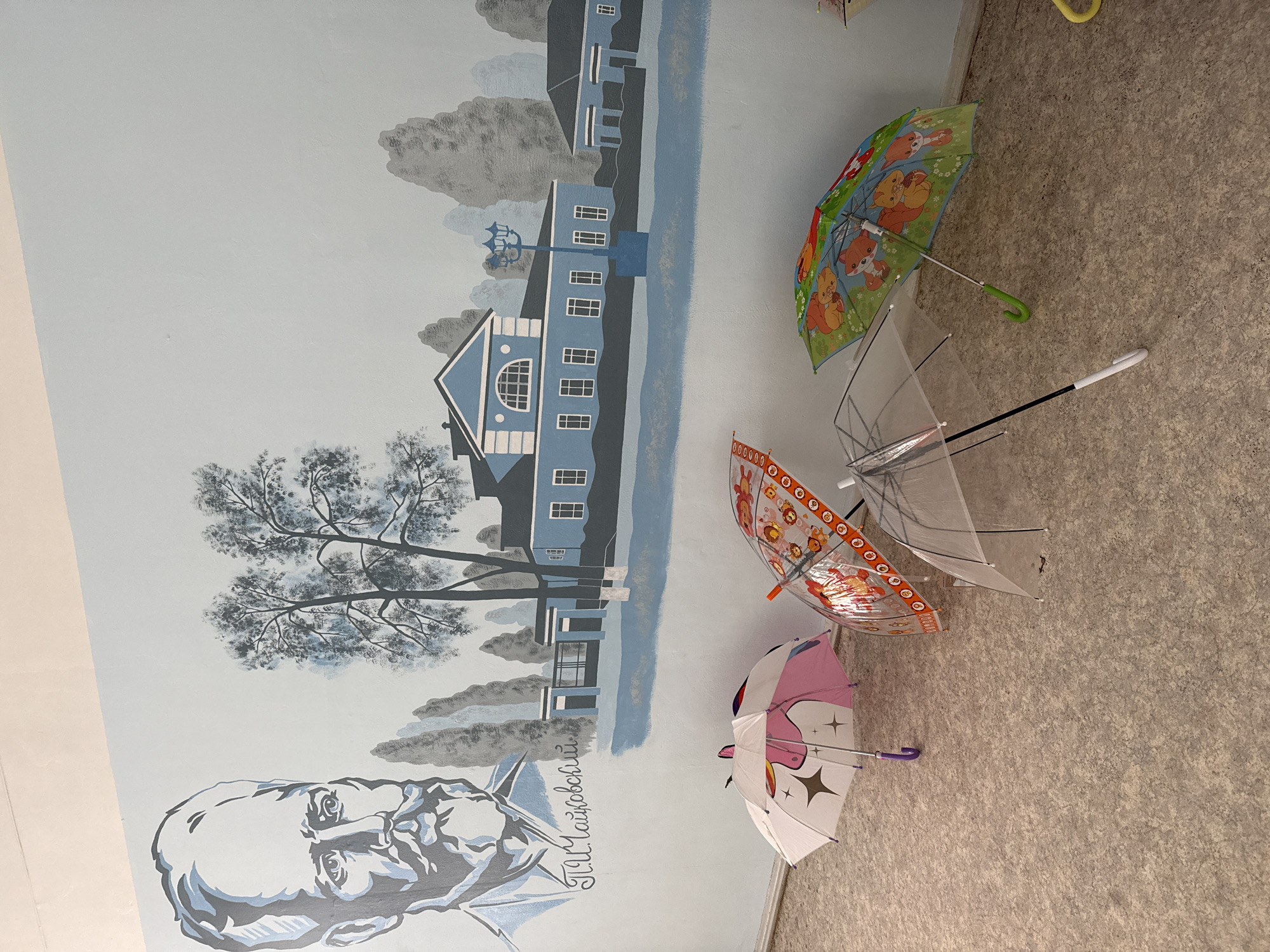 Children with umbrellas and street murals observed in Votkinsk