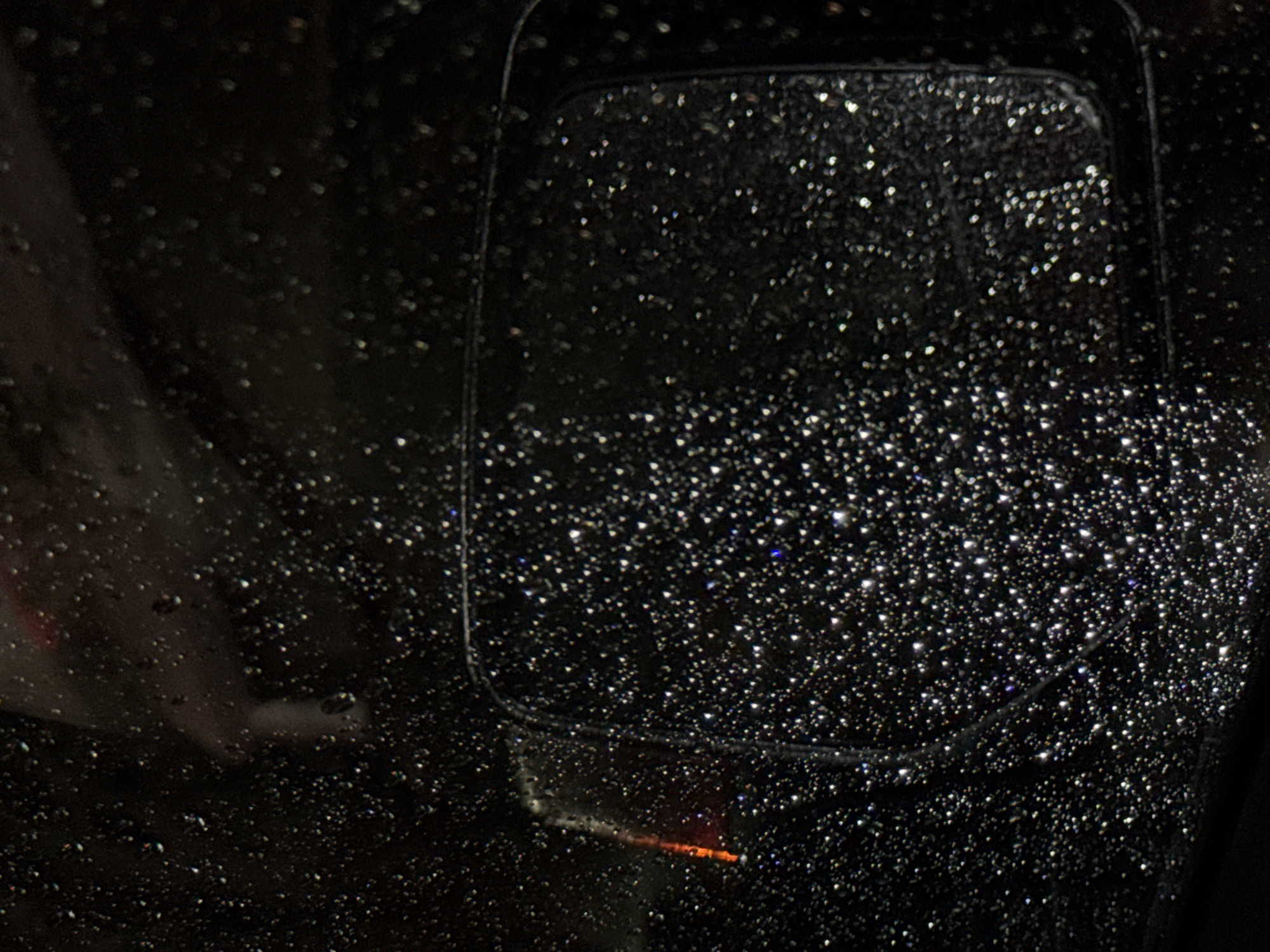 Rain-covered car mirror photographed in Mexico City