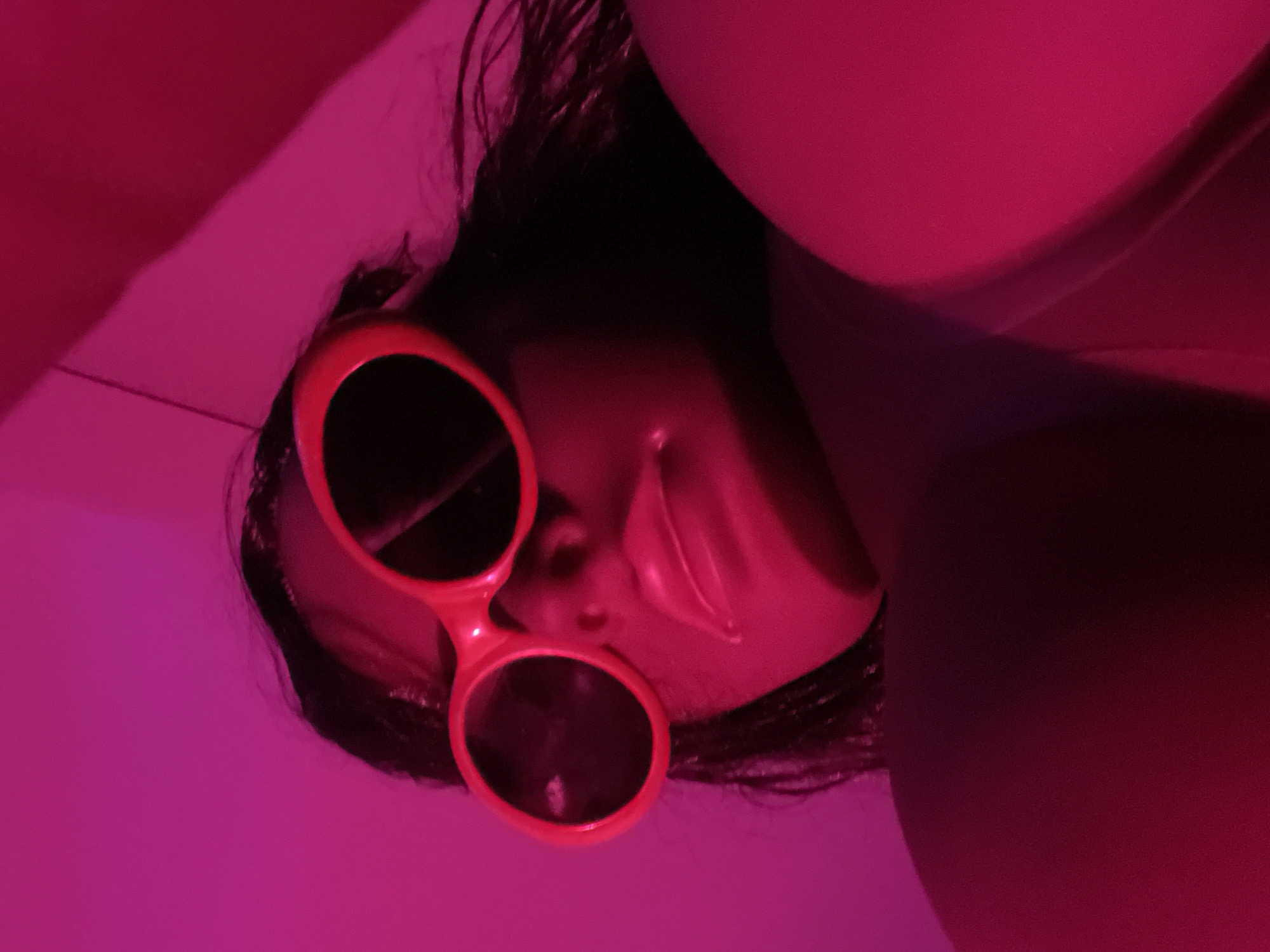 Colorful sunglasses and pink lighting in a disco-glam room