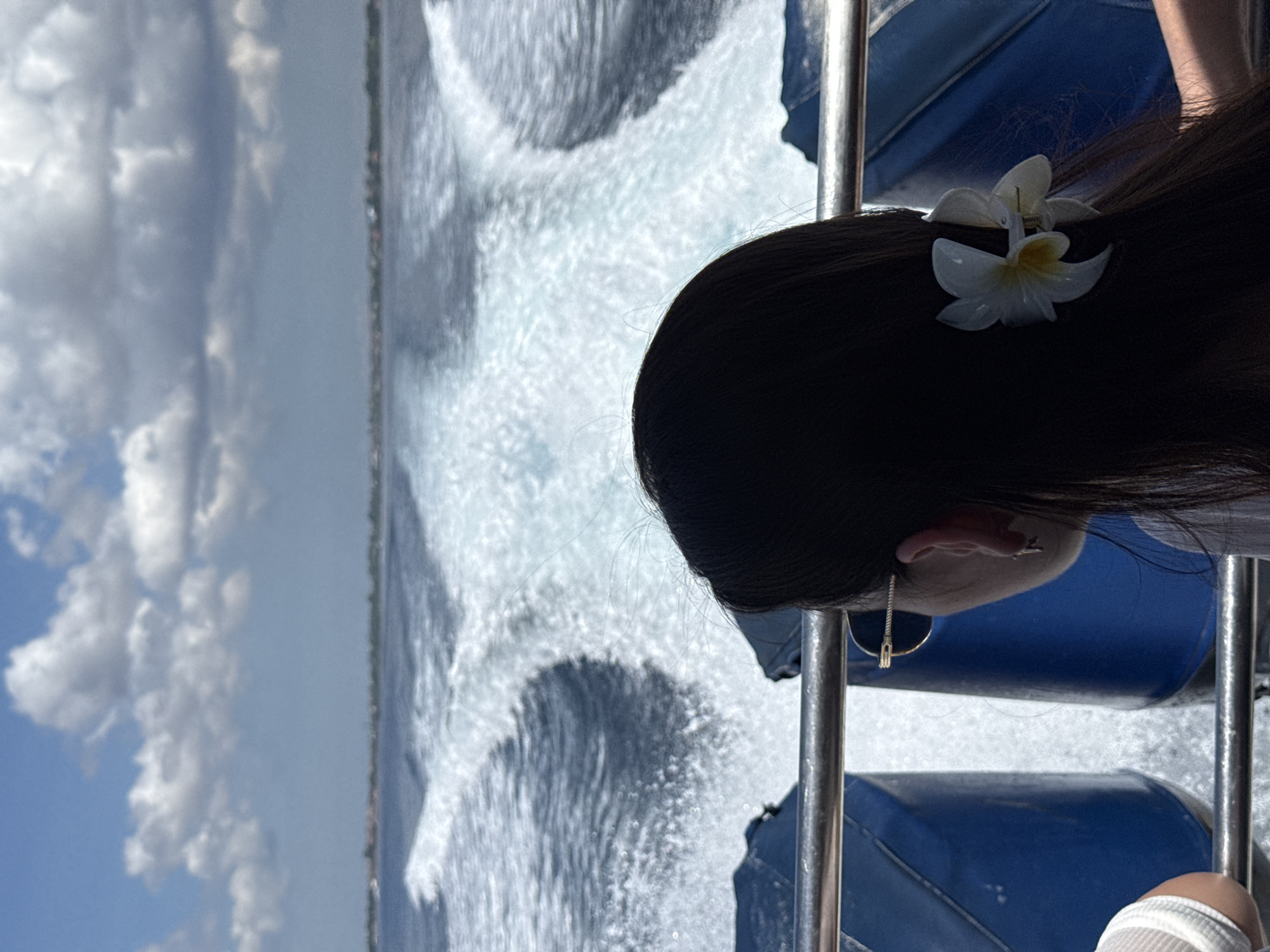 Person with flower aboard moving boat in Indonesia