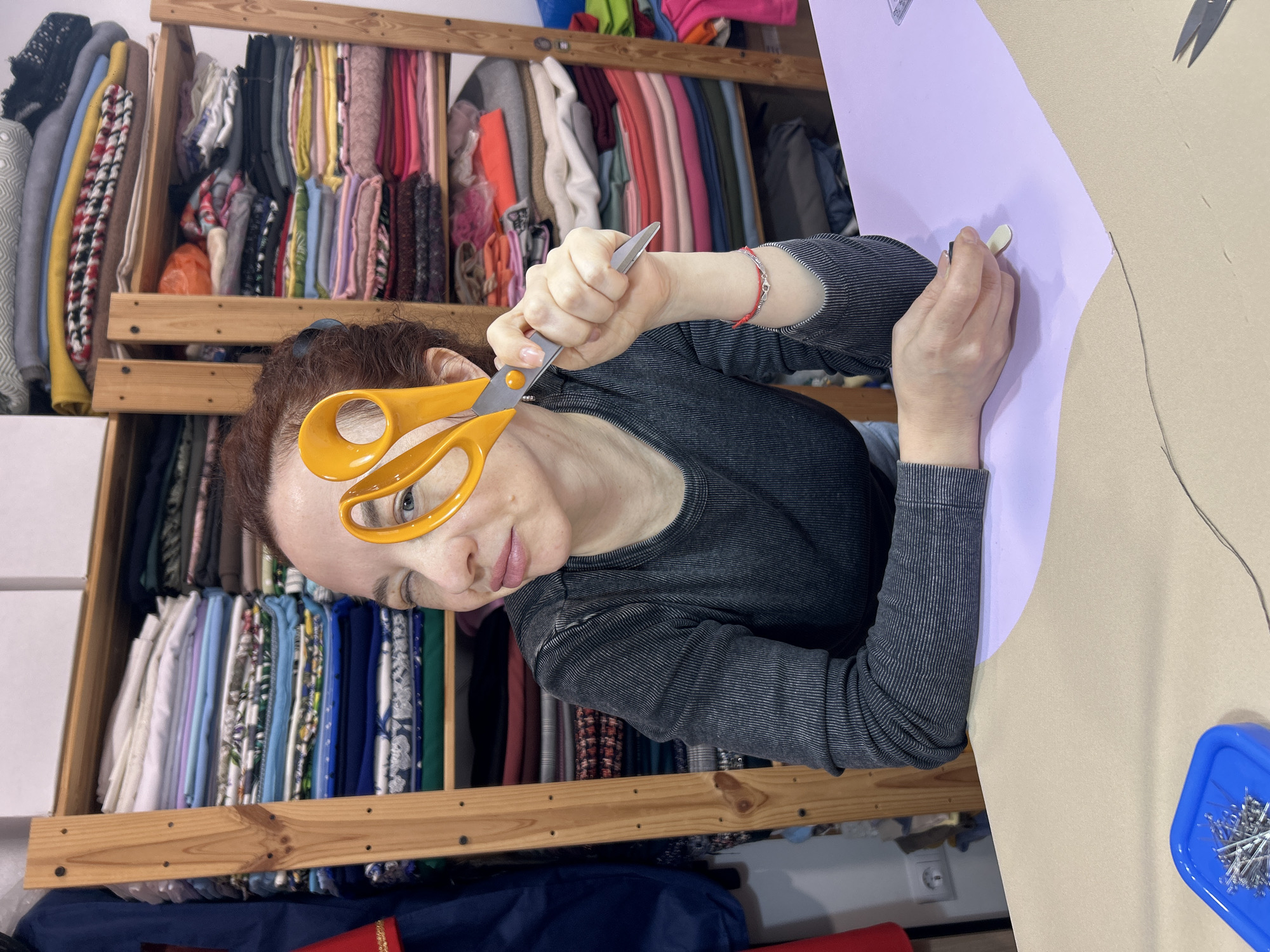 Woman works with scissors and fabrics in craft session