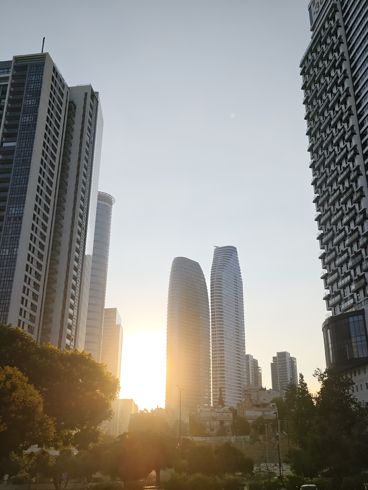 Givatayim's modern skyline from street level, clear day