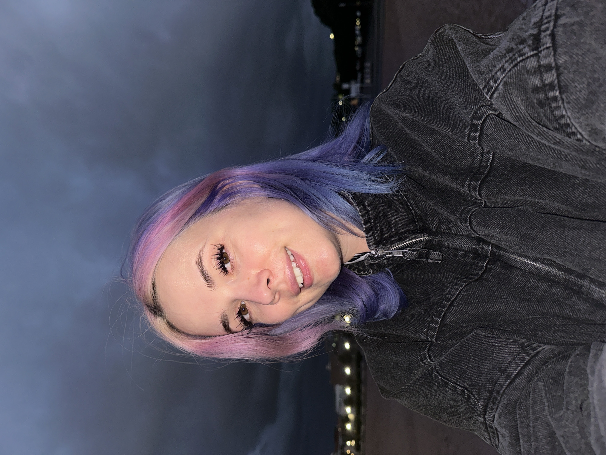 Woman with colorful hair visits Gijón beach at dusk