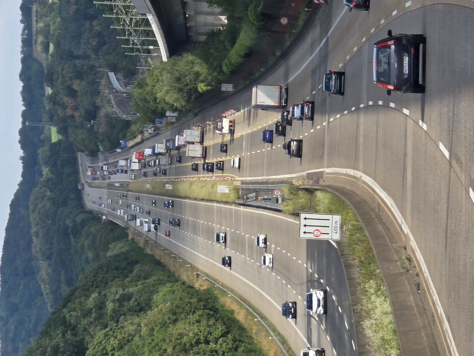 Rural German highway lined with dense trees and concrete barriers