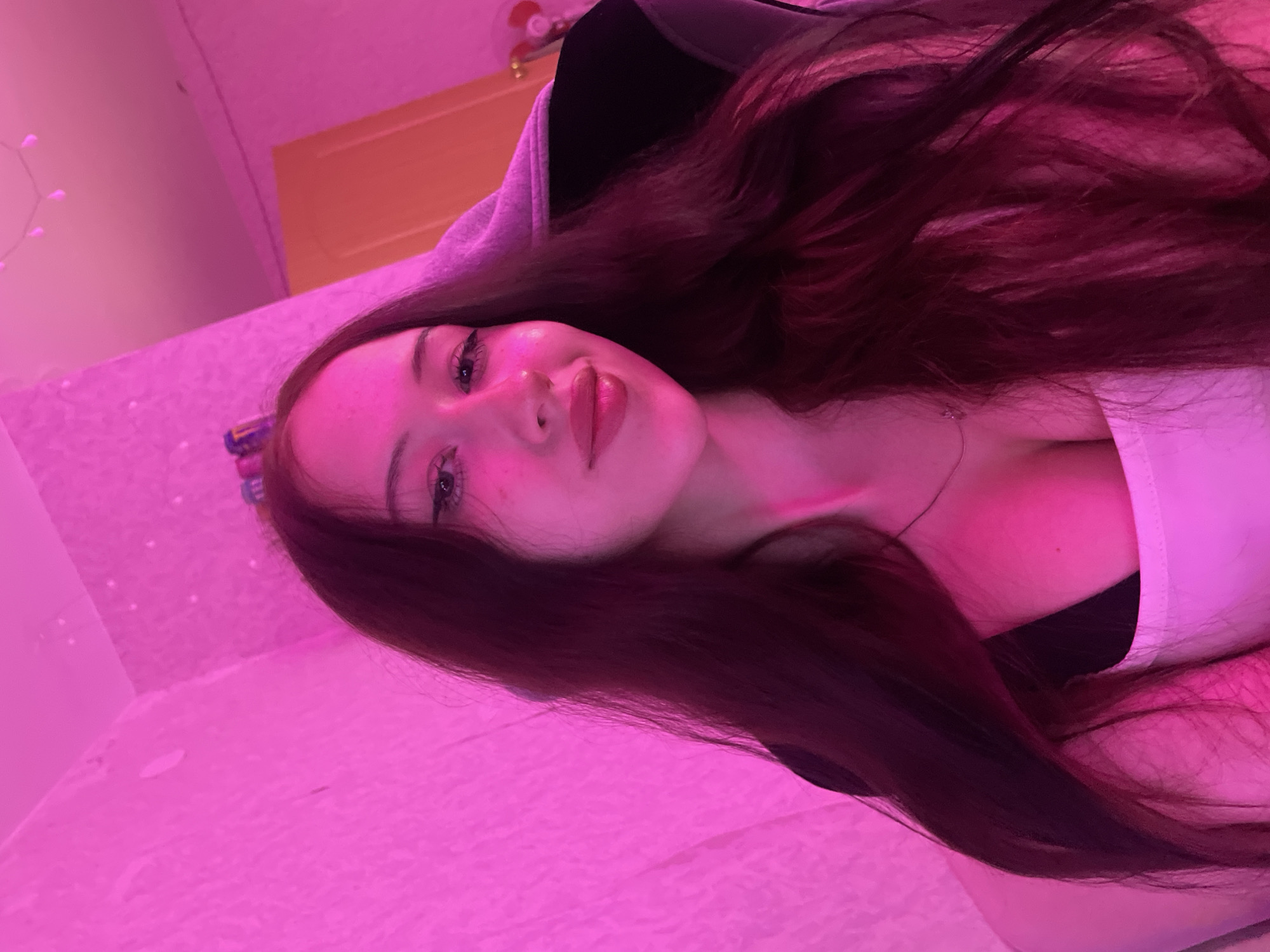 Woman documents evening selfie session in purple-lit Votkinsk room