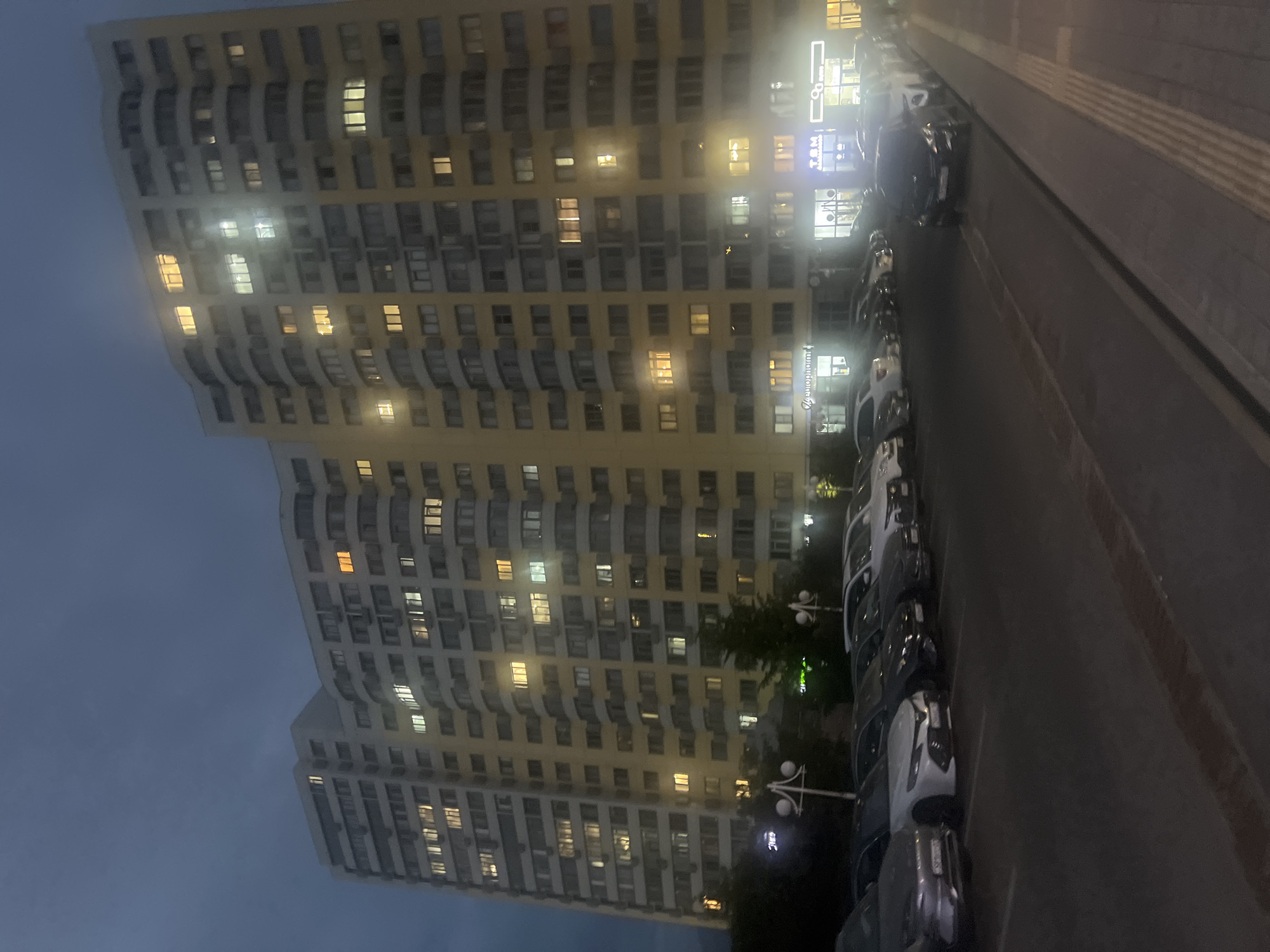 Almaty apartment complex lit up on a cloudy night